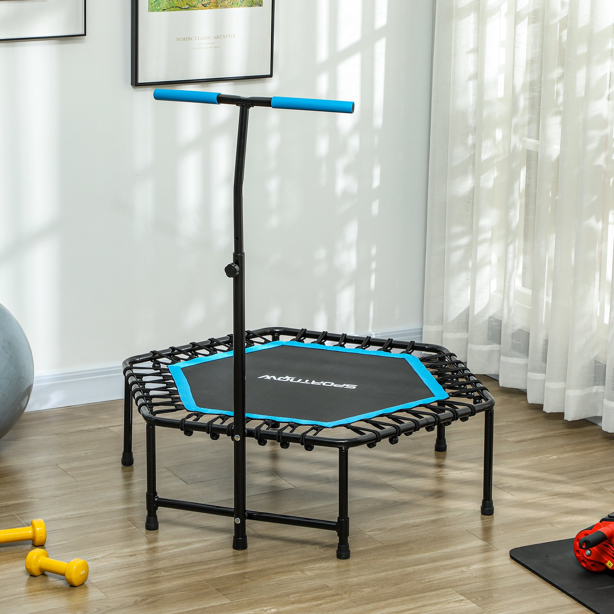 Pequeño trampolín interior con marco negro y superficie de salto azul. Tiene una barra y asas negras.