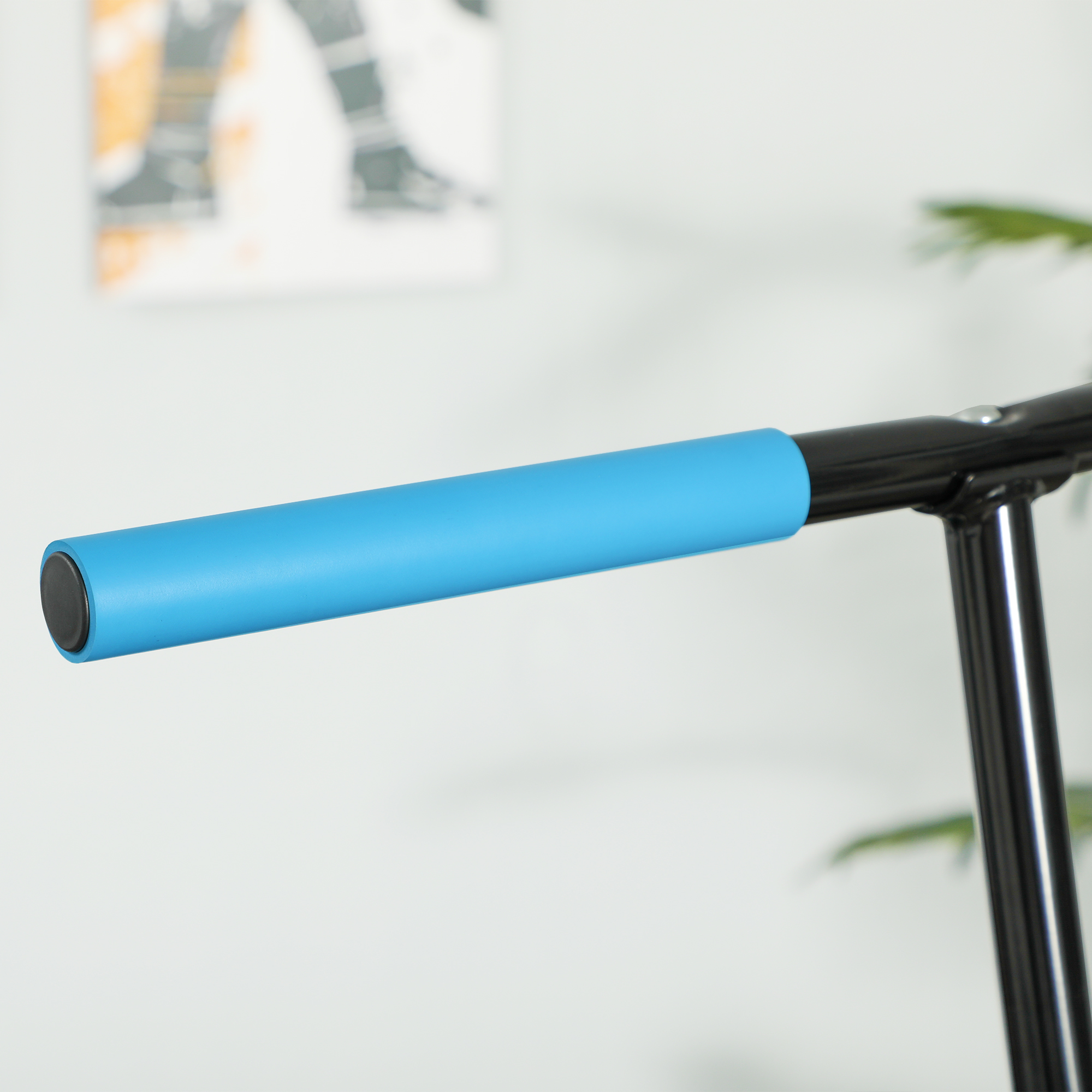 Manillar de patinete con agarre azul, frente a una pared.