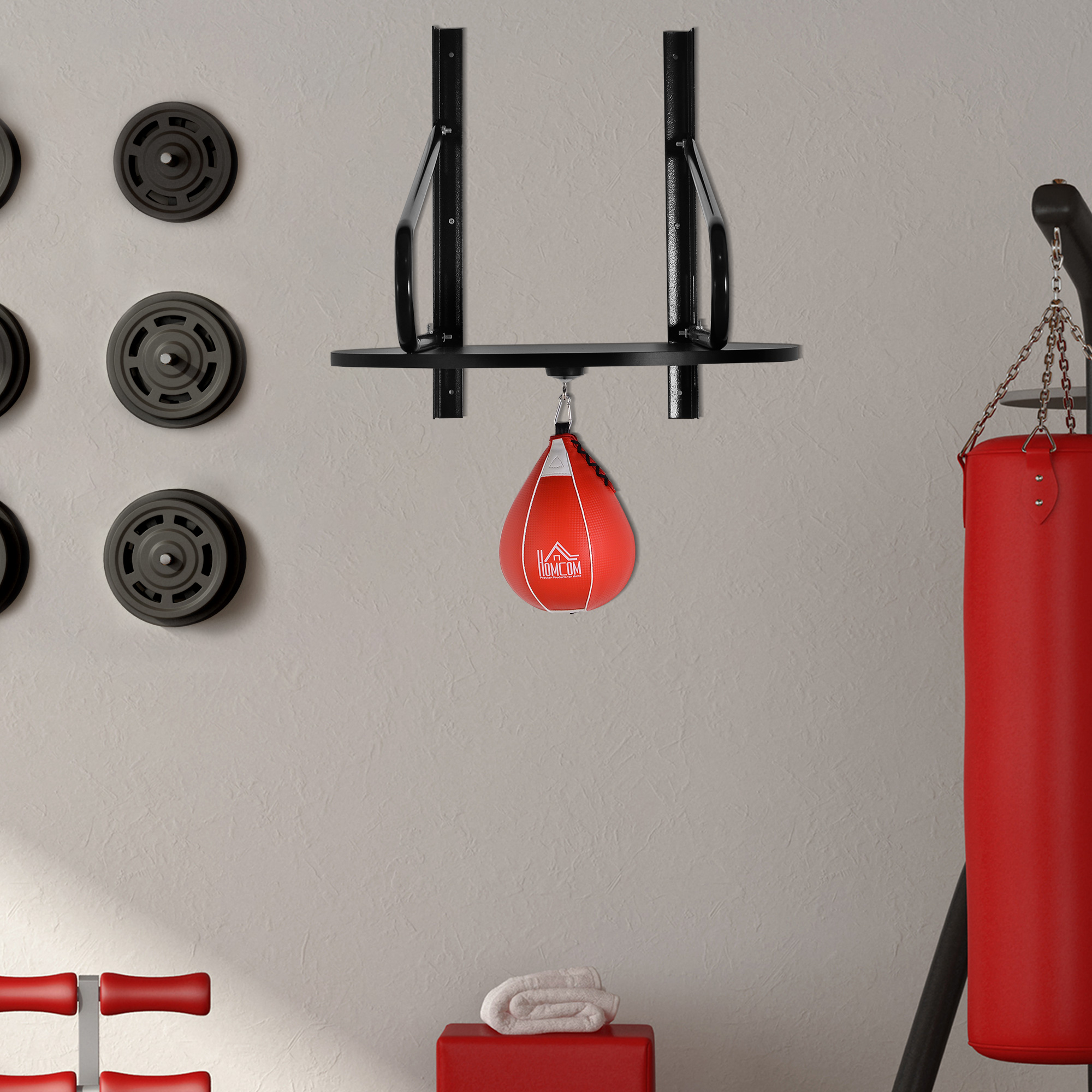Saco de boxeo y saco pesado colgados en una pared con pesas. Pared beige.