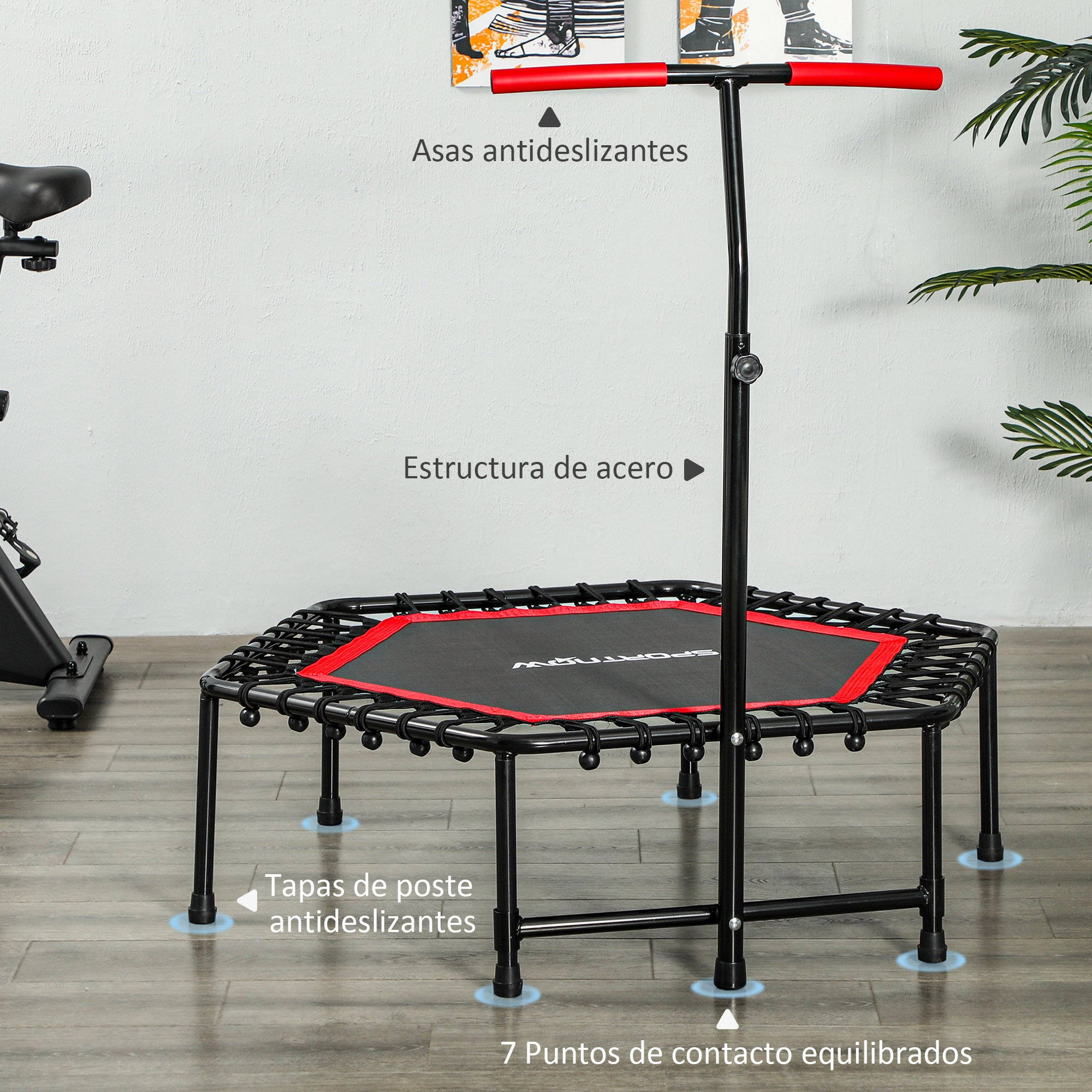 Un mini trampolín negro y rojo con asa y fondo de suelo de madera.