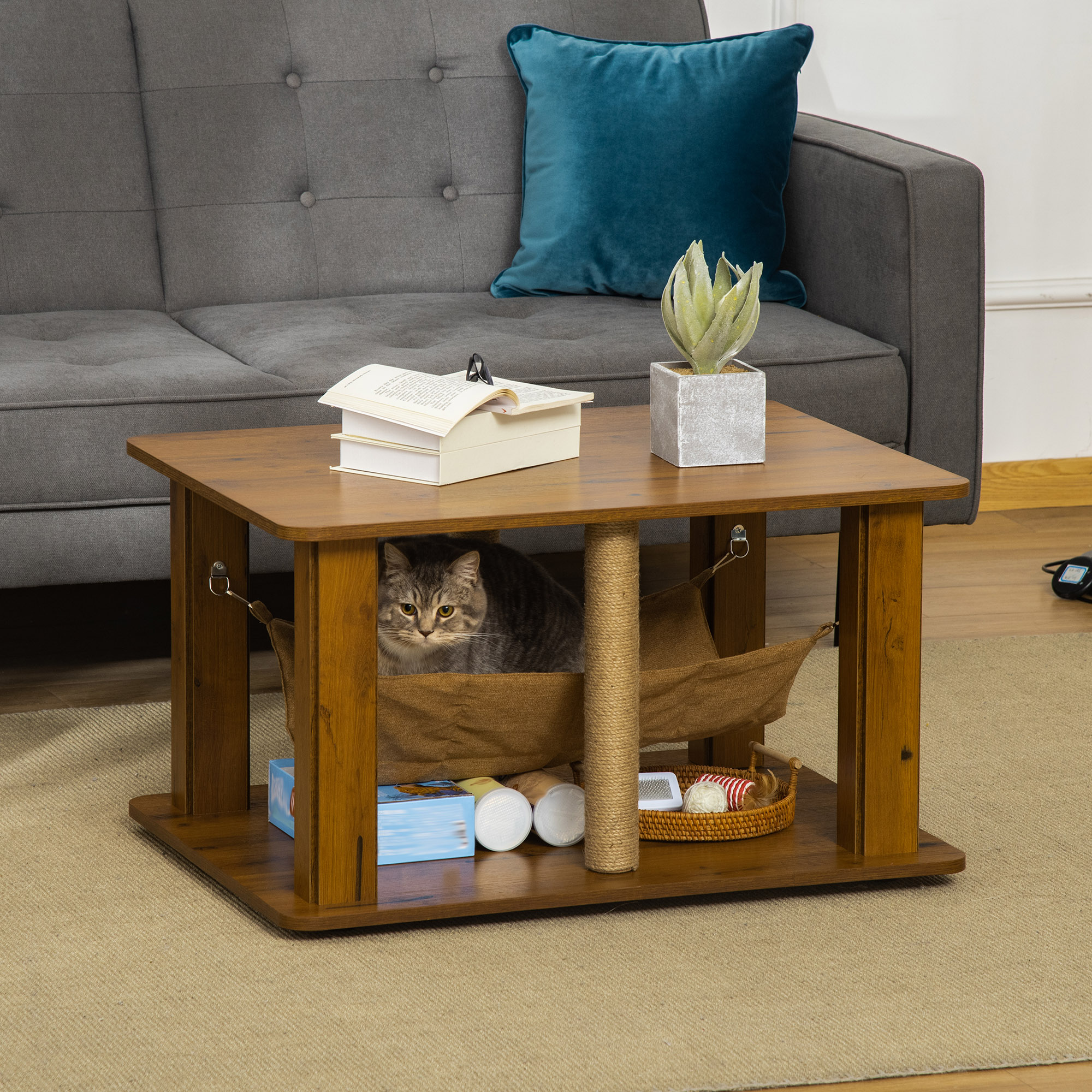 Mesa con árbol para gatos de madera con un gato dentro, un libro y una planta.