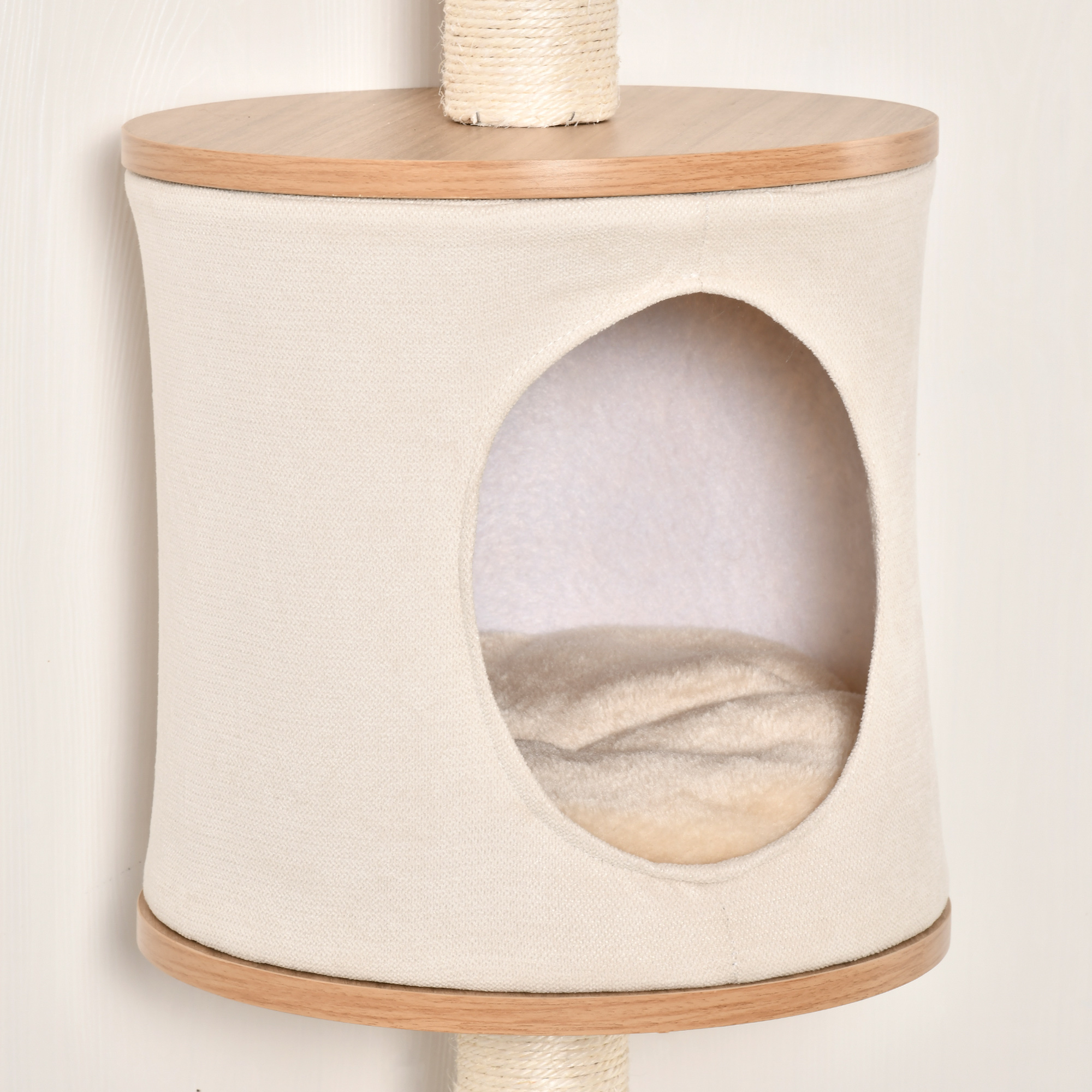 Árbol para gatos con cama de tela beige y rascador. La estructura es de madera y cuerda.