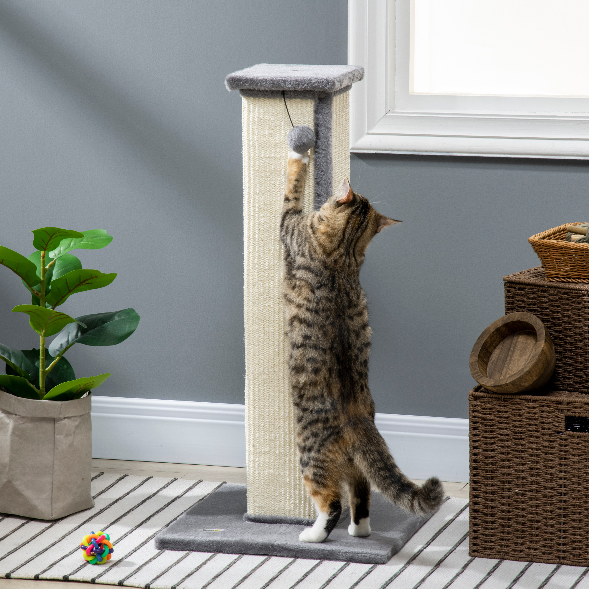 Rascador para gatos con un gato alcanzando un juguete.