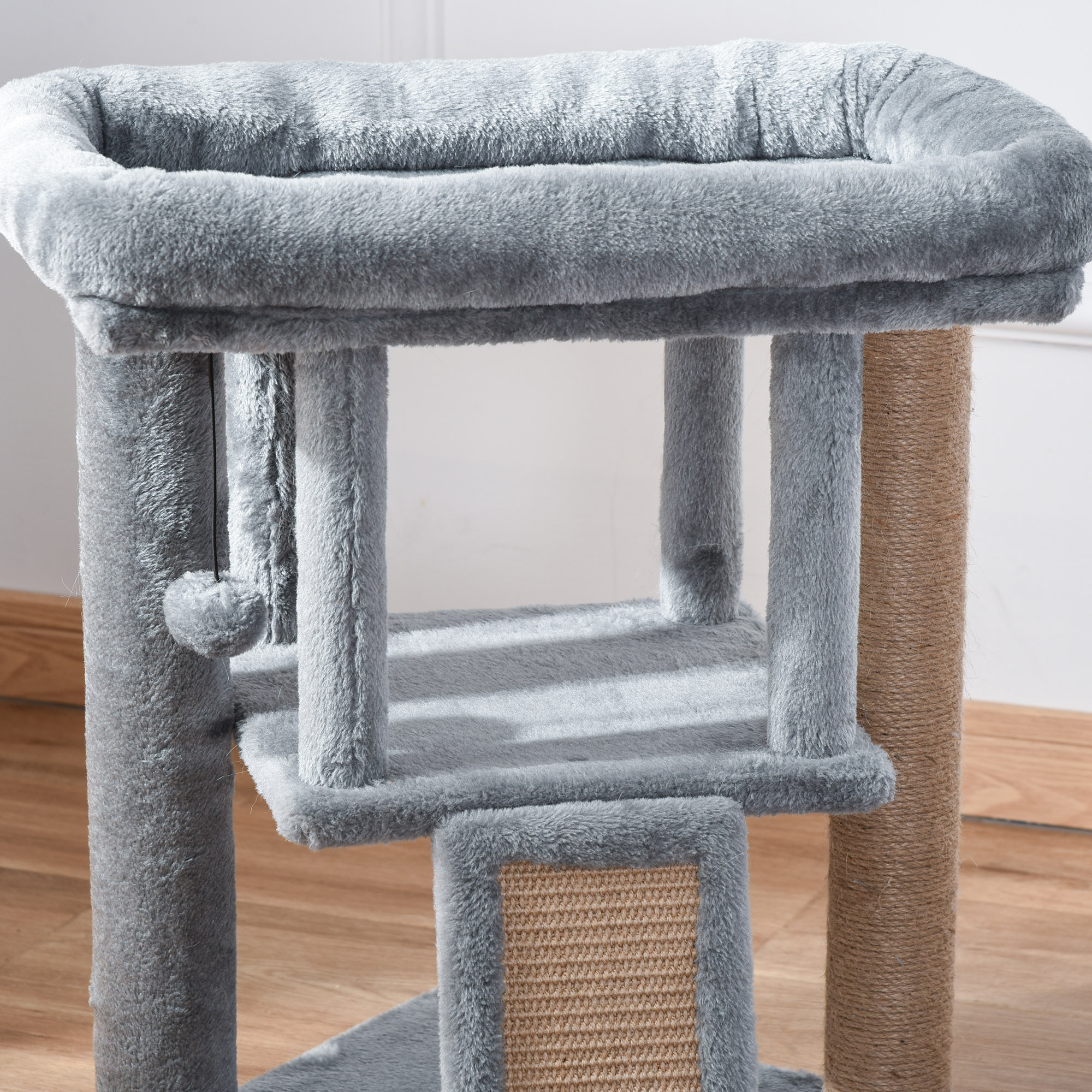 Primer plano de un árbol para gatos gris con múltiples niveles y postes rascadores.