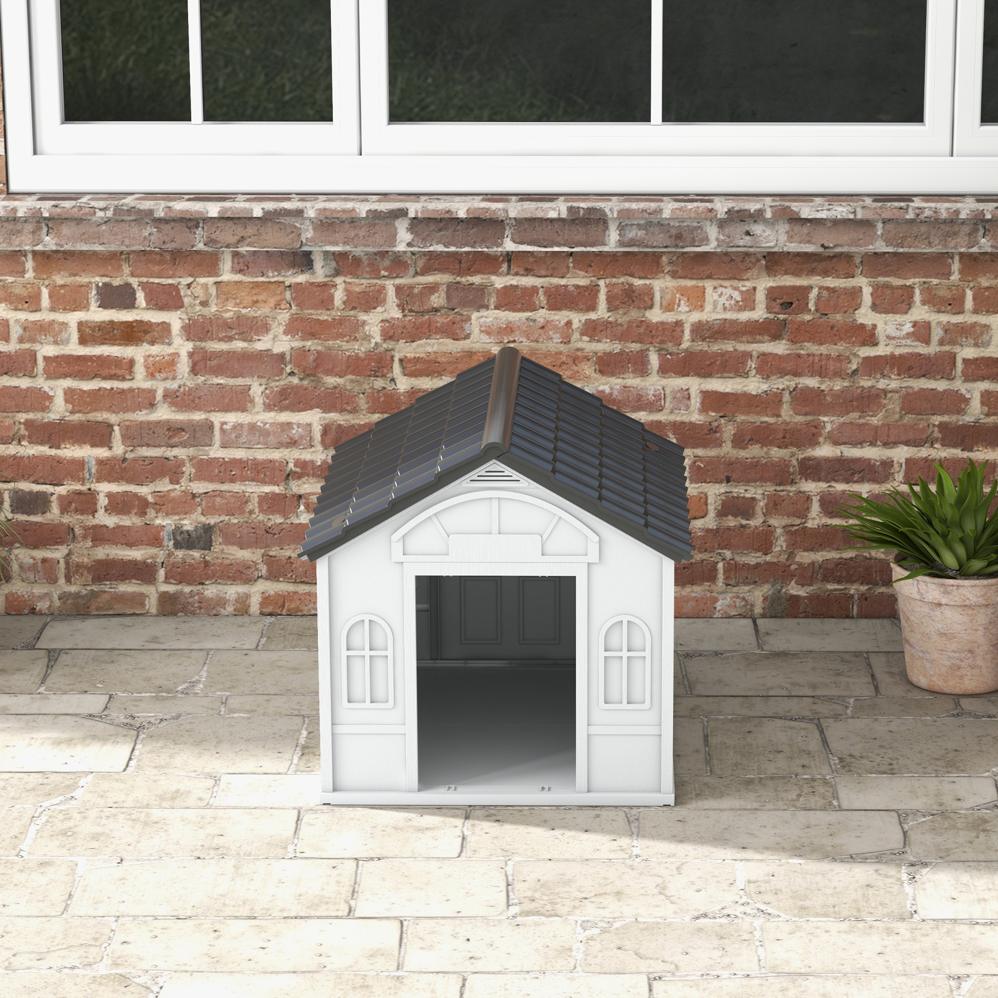 Una caseta blanca para perros en un patio trasero. Un muro de ladrillo y una ventana al fondo.