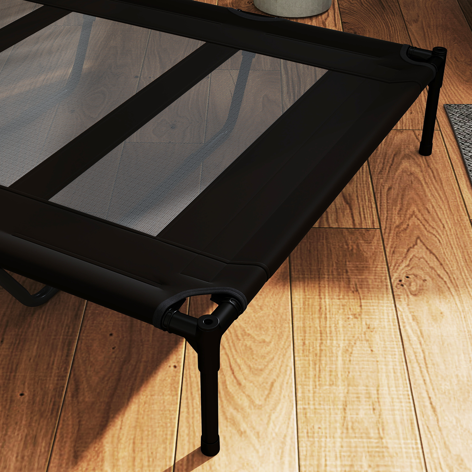 Cama negra para mascotas en un piso de madera.