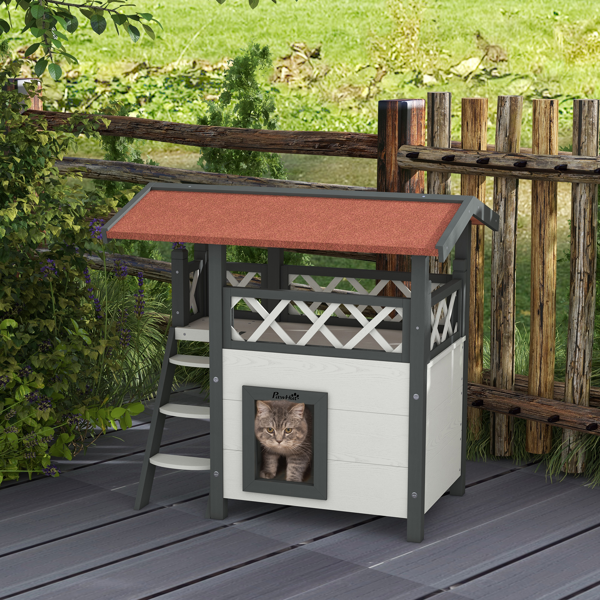 Un gato en una casa para gatos blanca y gris con escalera, sobre una cubierta de madera.