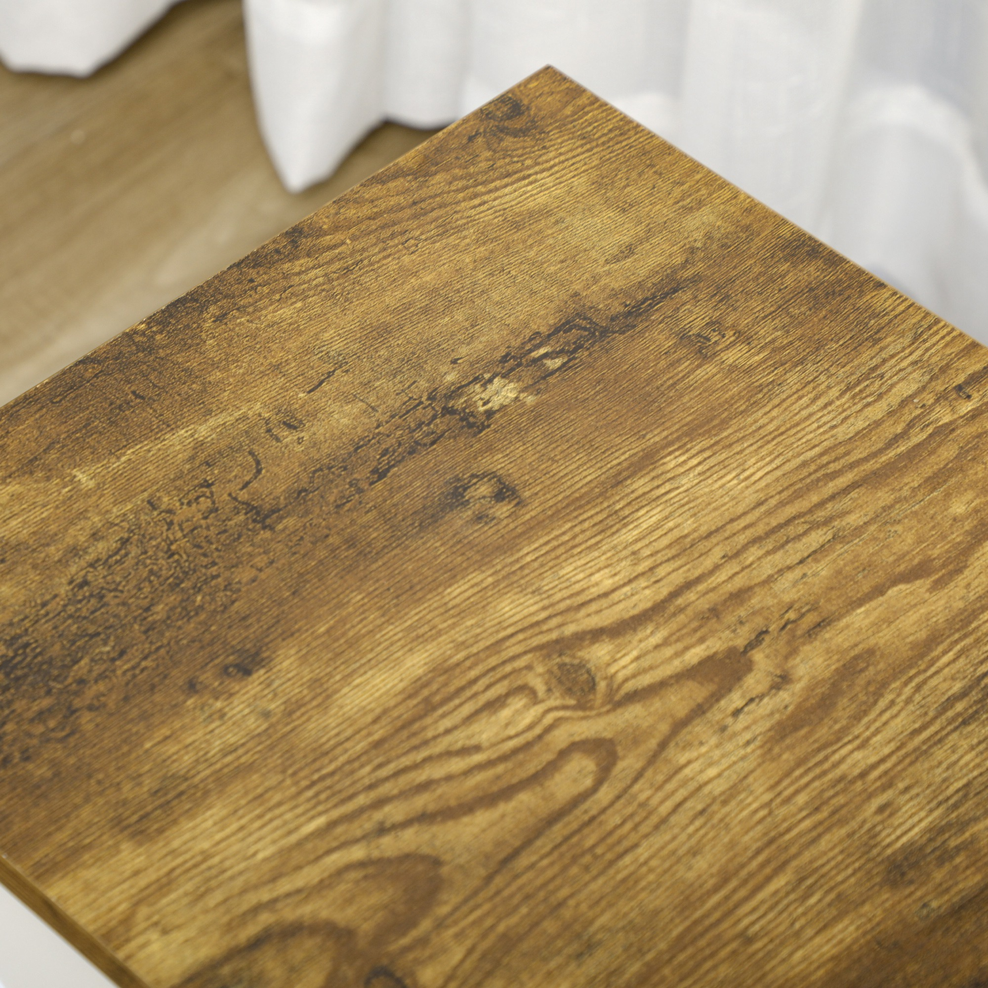 Primer plano de una superficie de mesa de madera. La madera tiene un patrón de vetas texturizadas.