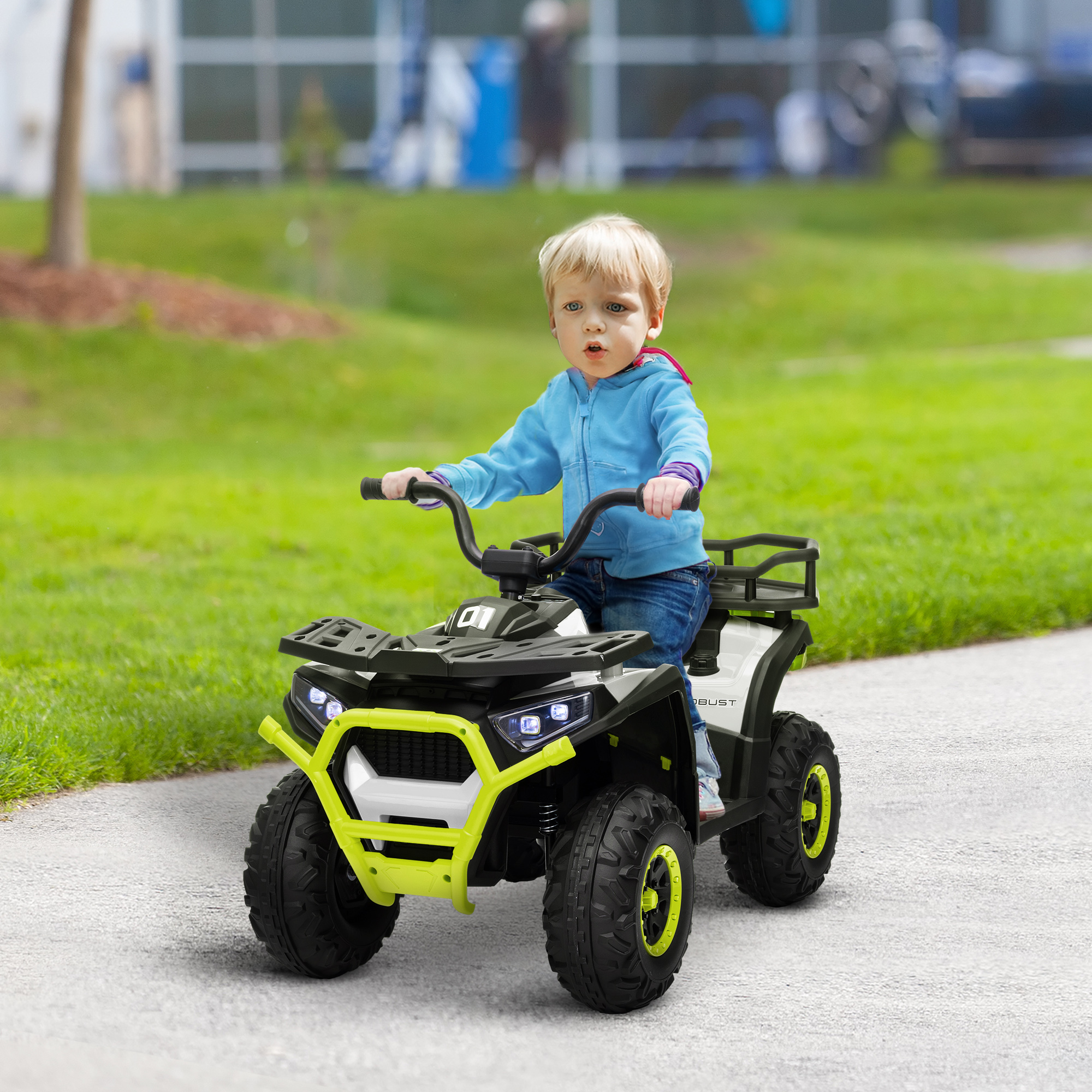 Un niño pequeño con una chaqueta azul conduce un quad negro y amarillo por un camino pavimentado.
