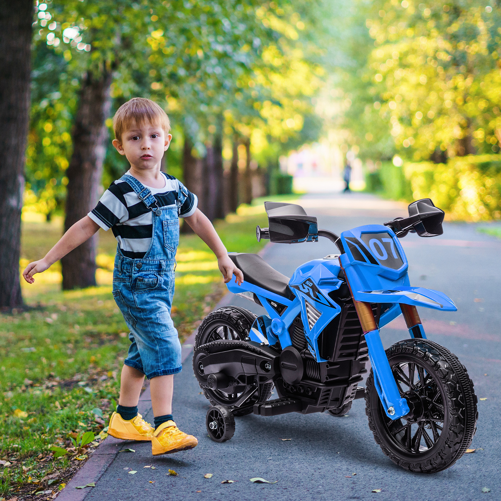 Un niño pequeño con una motocicleta de juguete azul está de pie en una acera. La motocicleta es azul.