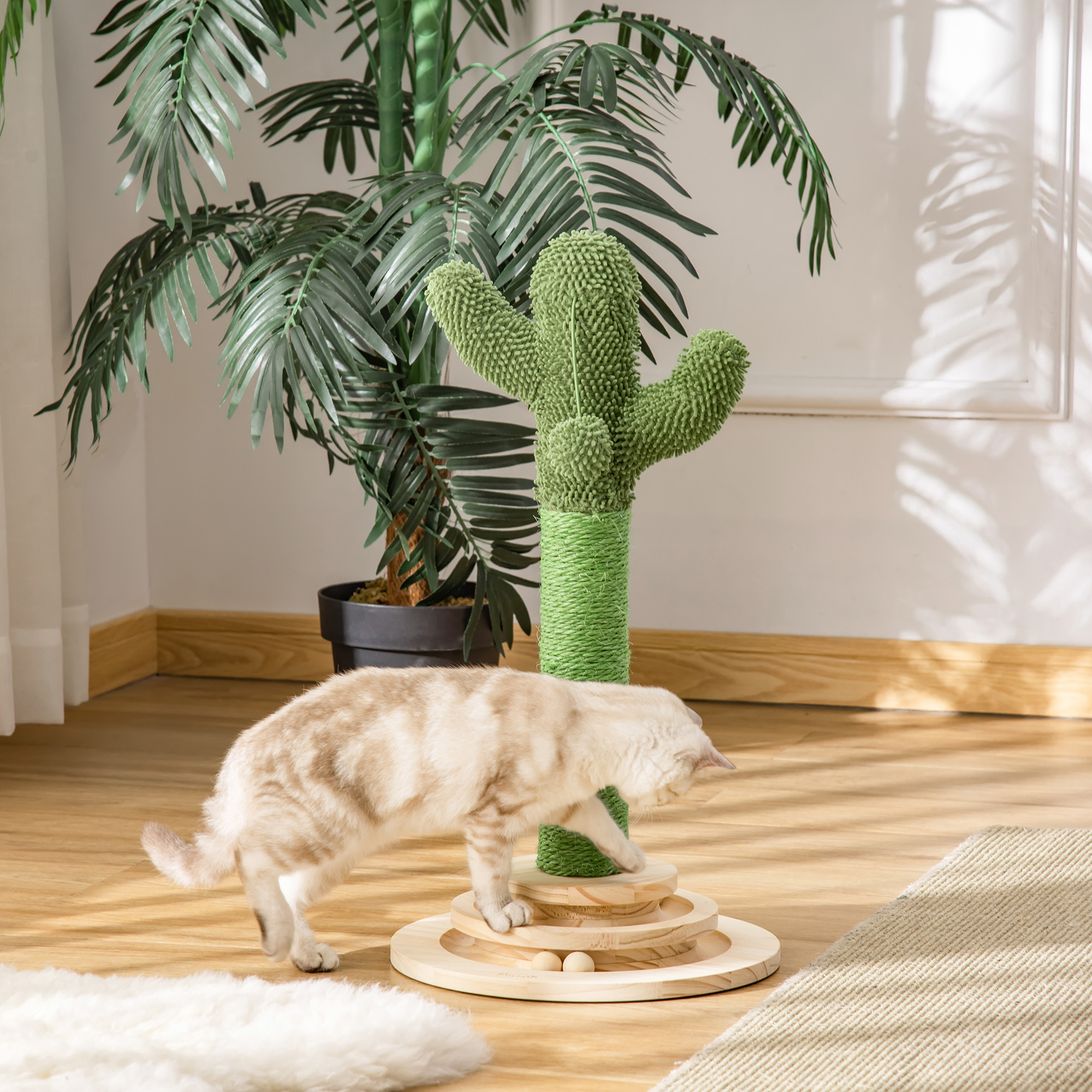 Un gato juega con un rascador con forma de cactus.