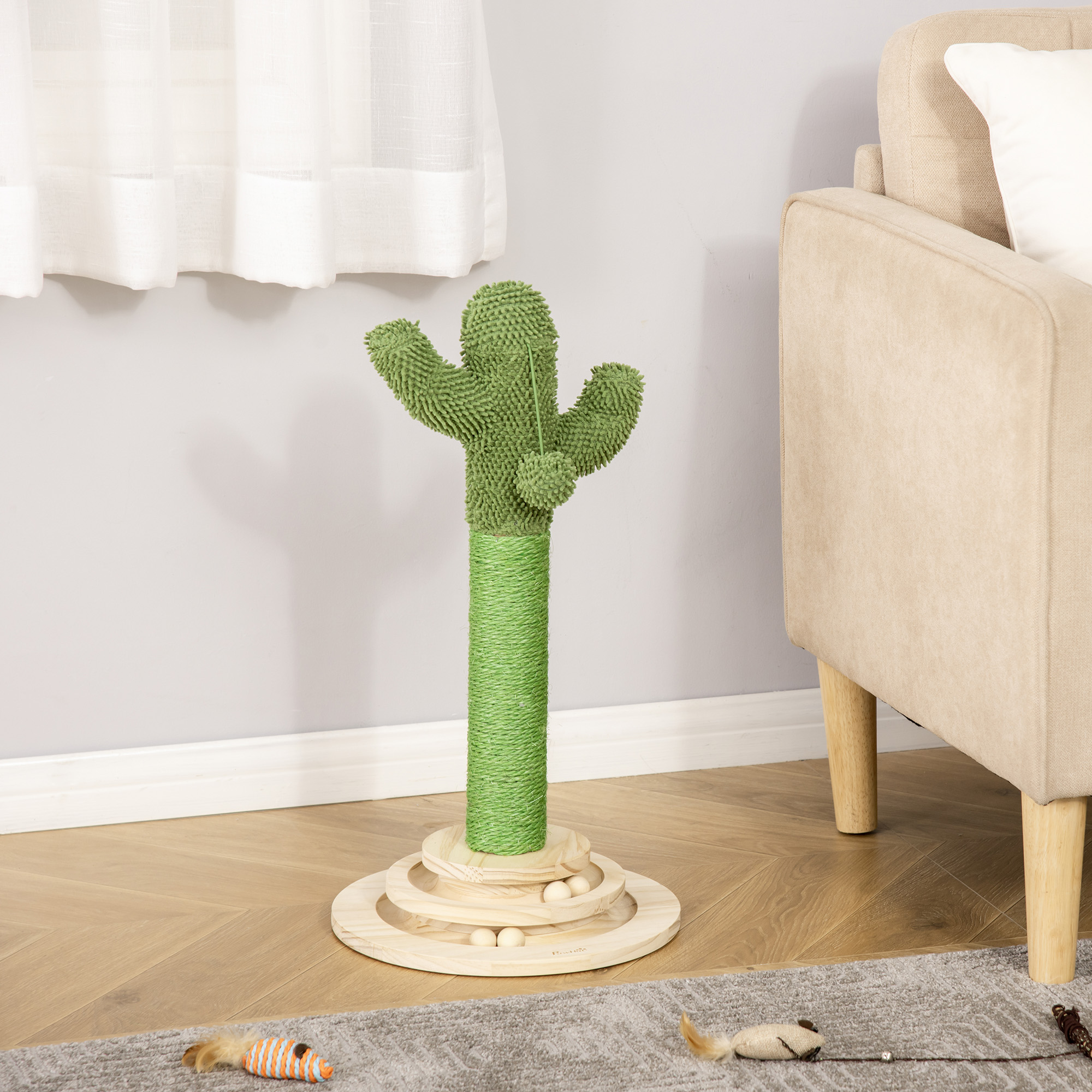 Rascador para gatos en forma de cactus verde con base y bolas de madera. Contra una pared gris.