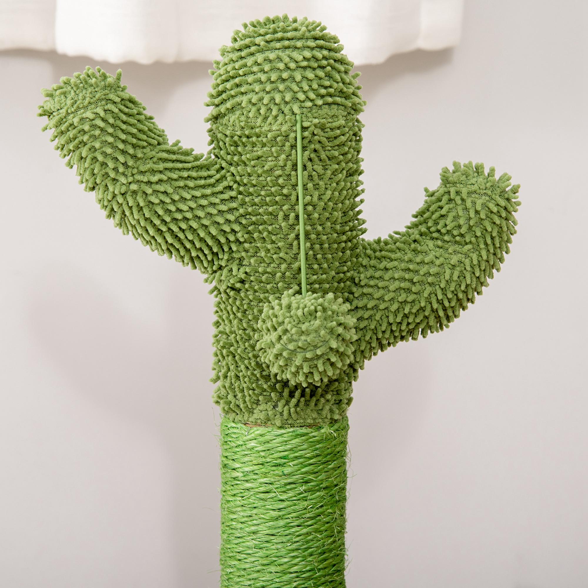 Un rascador para gatos en forma de cactus verde con superficie texturizada, sobre un fondo blanco.