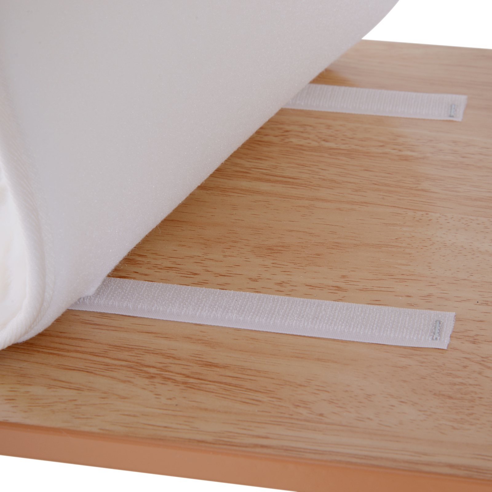 Mesa de madera con tela blanca. La tela cubre parcialmente la mesa y se sujeta con cintas de velcro blancas.