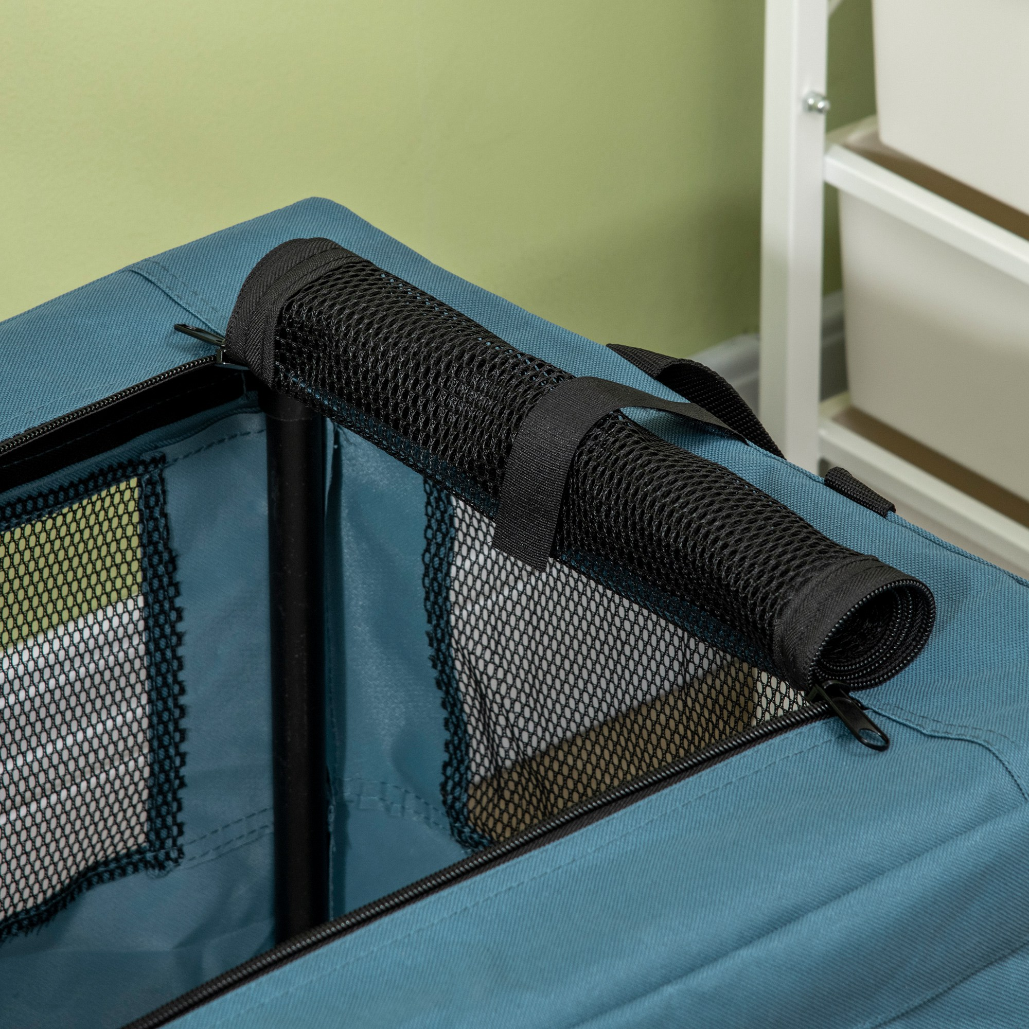 Transportín azul para mascotas con parte superior de malla negra y cubierta enrollada de malla.