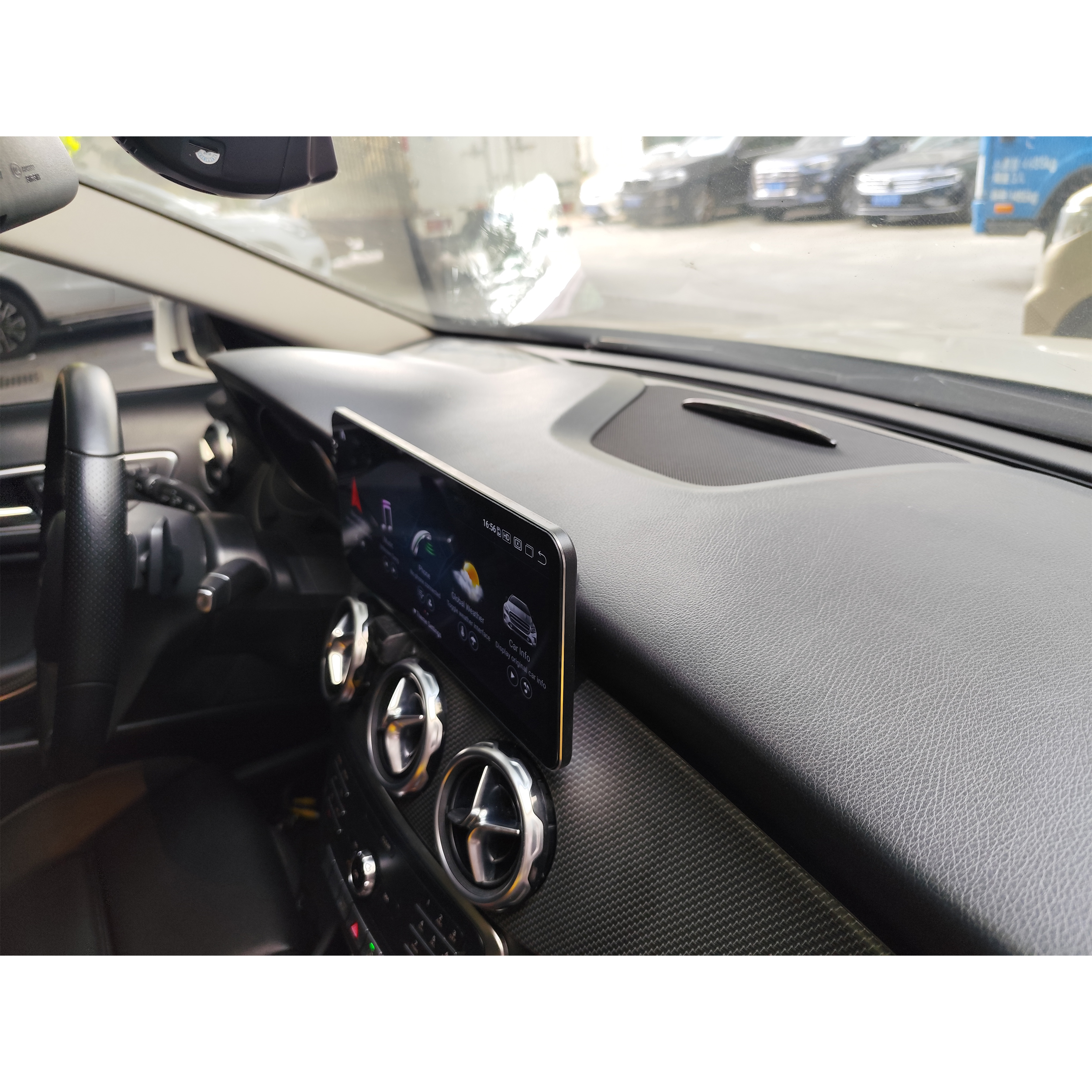 Auto-Armaturenbrett mit einem Bildschirm, der Navigation zeigt. Verschiedene Knöpfe und Lüftungsschlitze sind sichtbar.