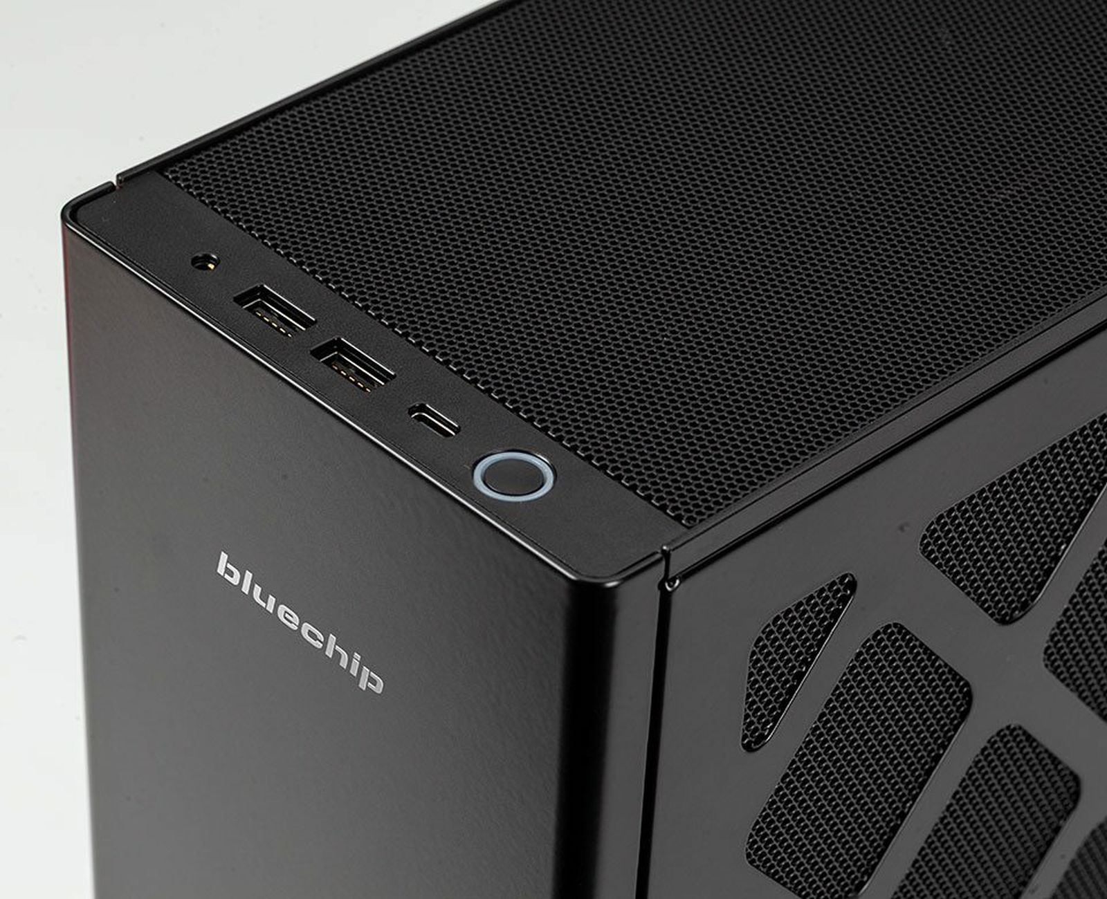 Angolo del case del computer nero con porte, un pulsante di accensione e il logo bluechip. Sfondo bianco.