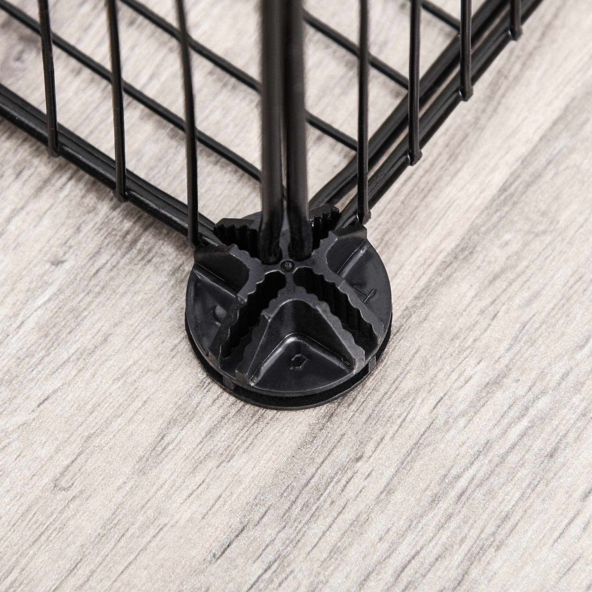Primer plano de una esquina de estante de alambre negro con un conector de plástico negro.