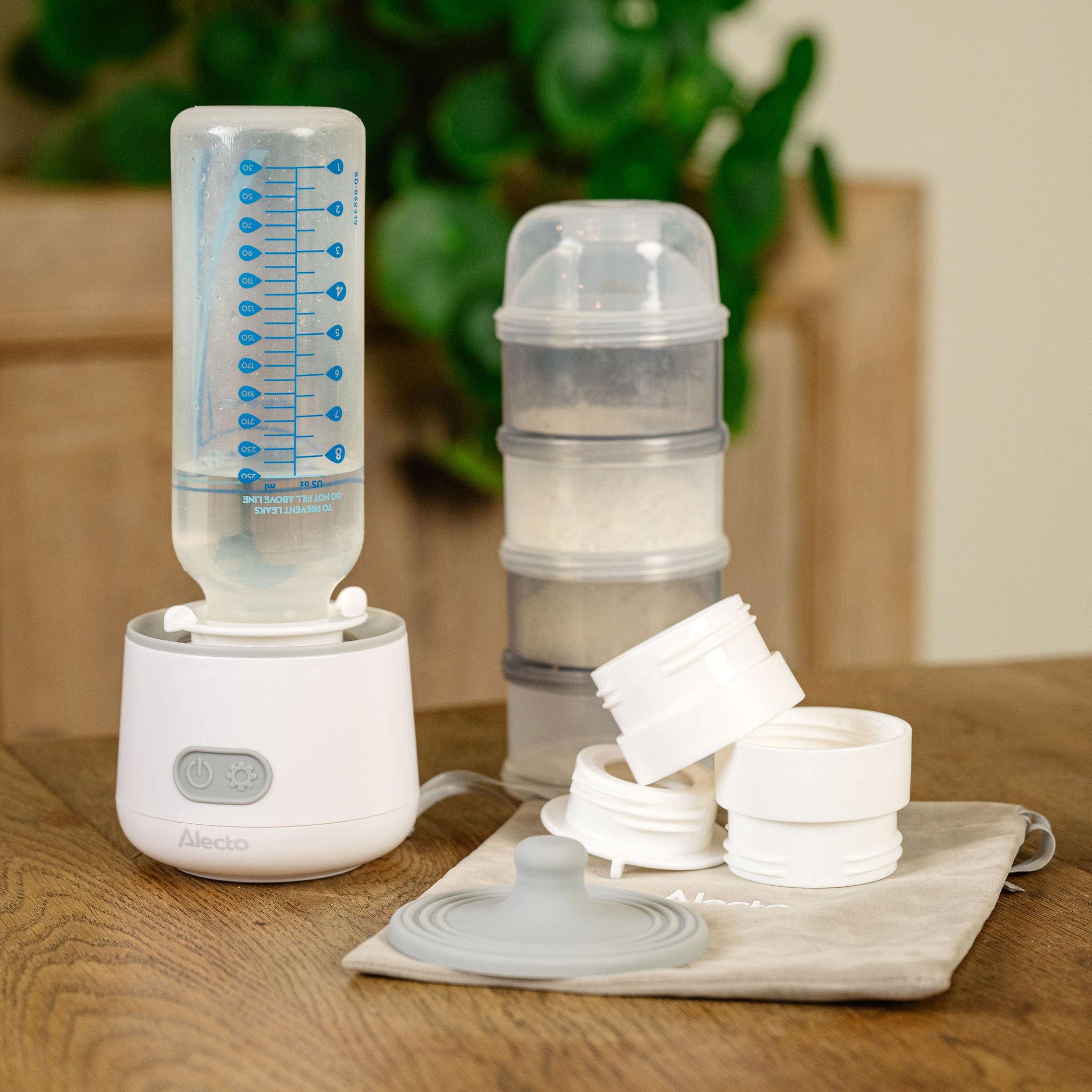 Babyflaschenwärmer und Milchpulverbehälter mit Zubehör. Weißer Hintergrund, Innenraum.