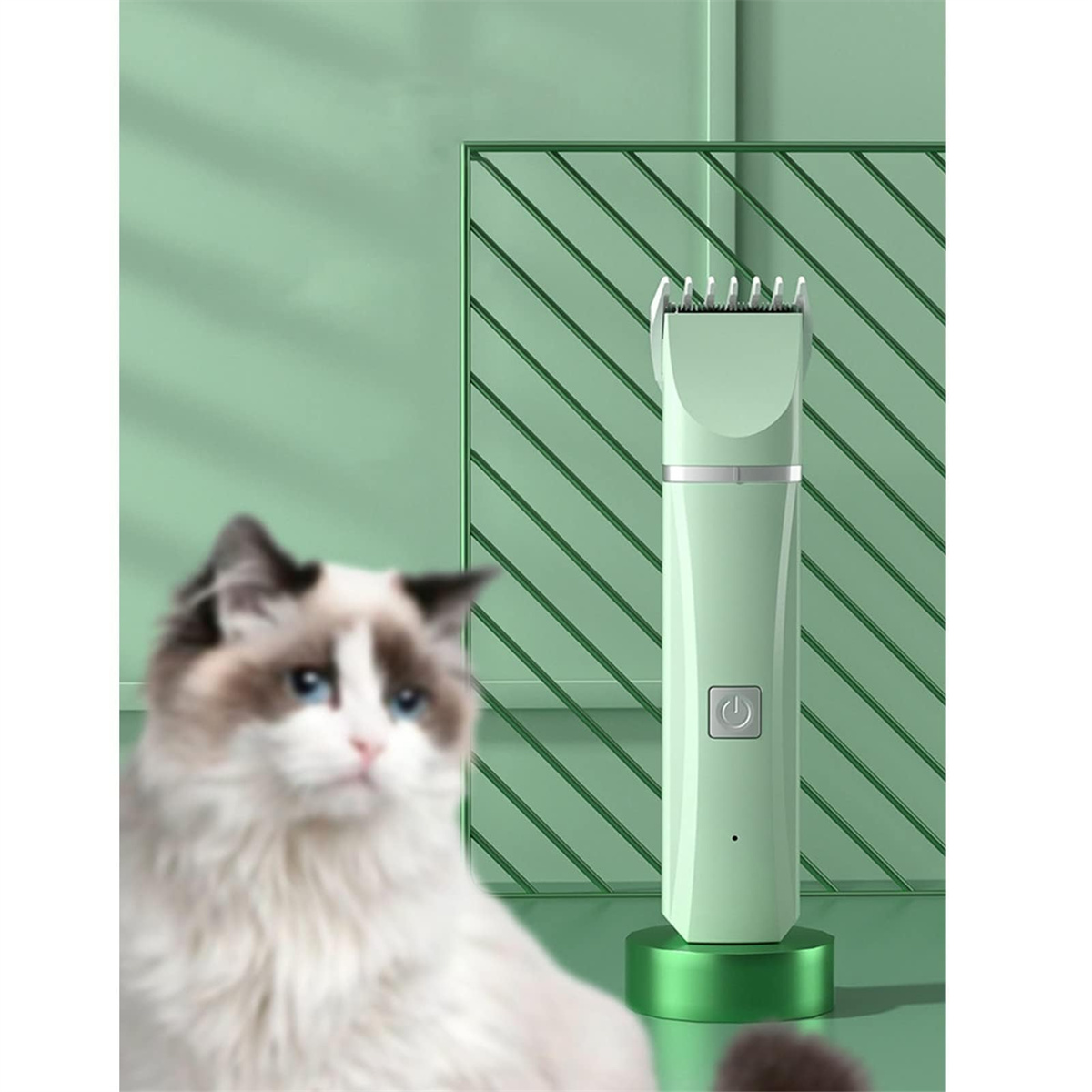 Ein hellgrüner Haarschneider für Haustiere steht auf einem grünen Ständer, mit einer unscharfen Katze im Vordergrund.