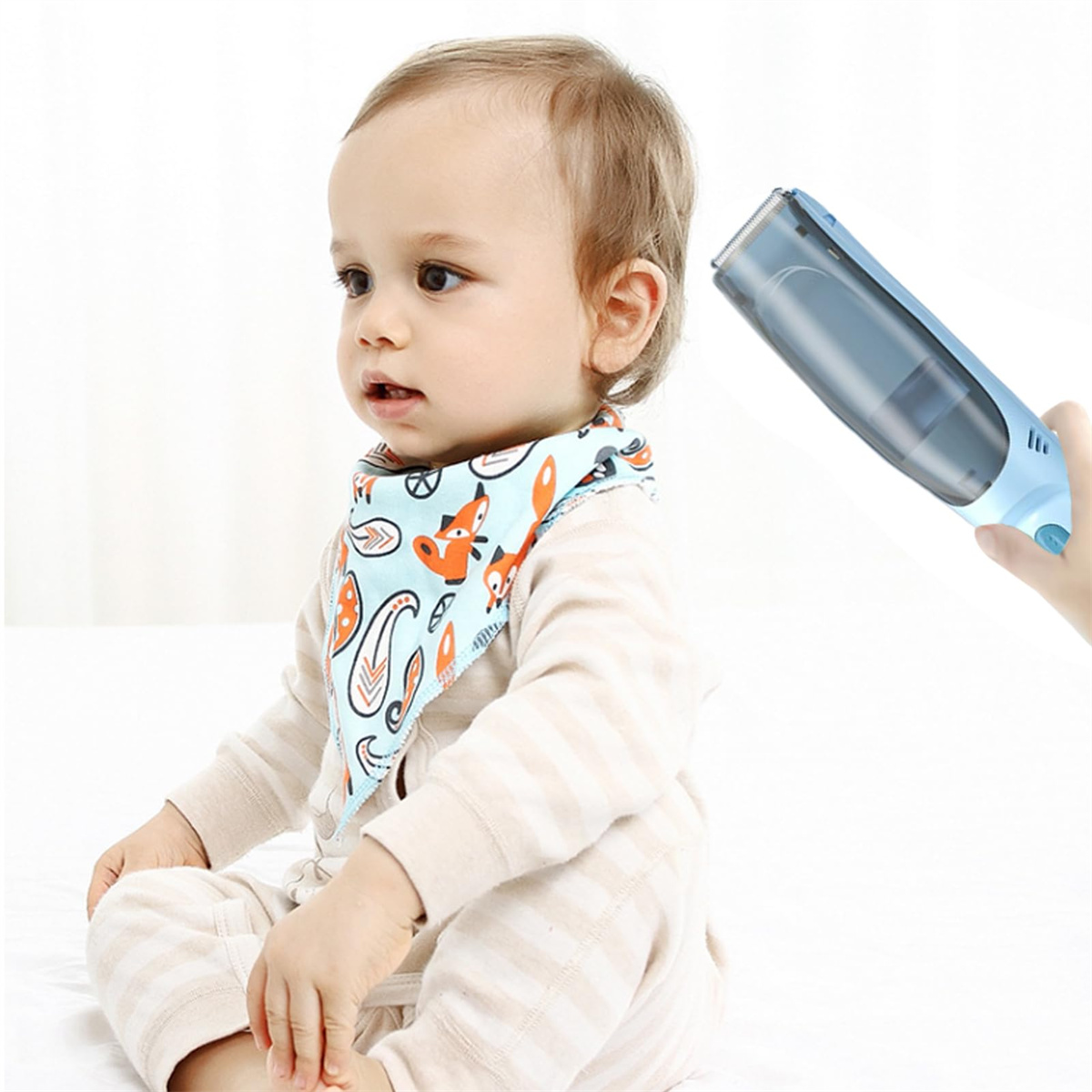 Baby mit Lätzchen, wird mit einem blauen elektrischen Haarschneider getrimmt.