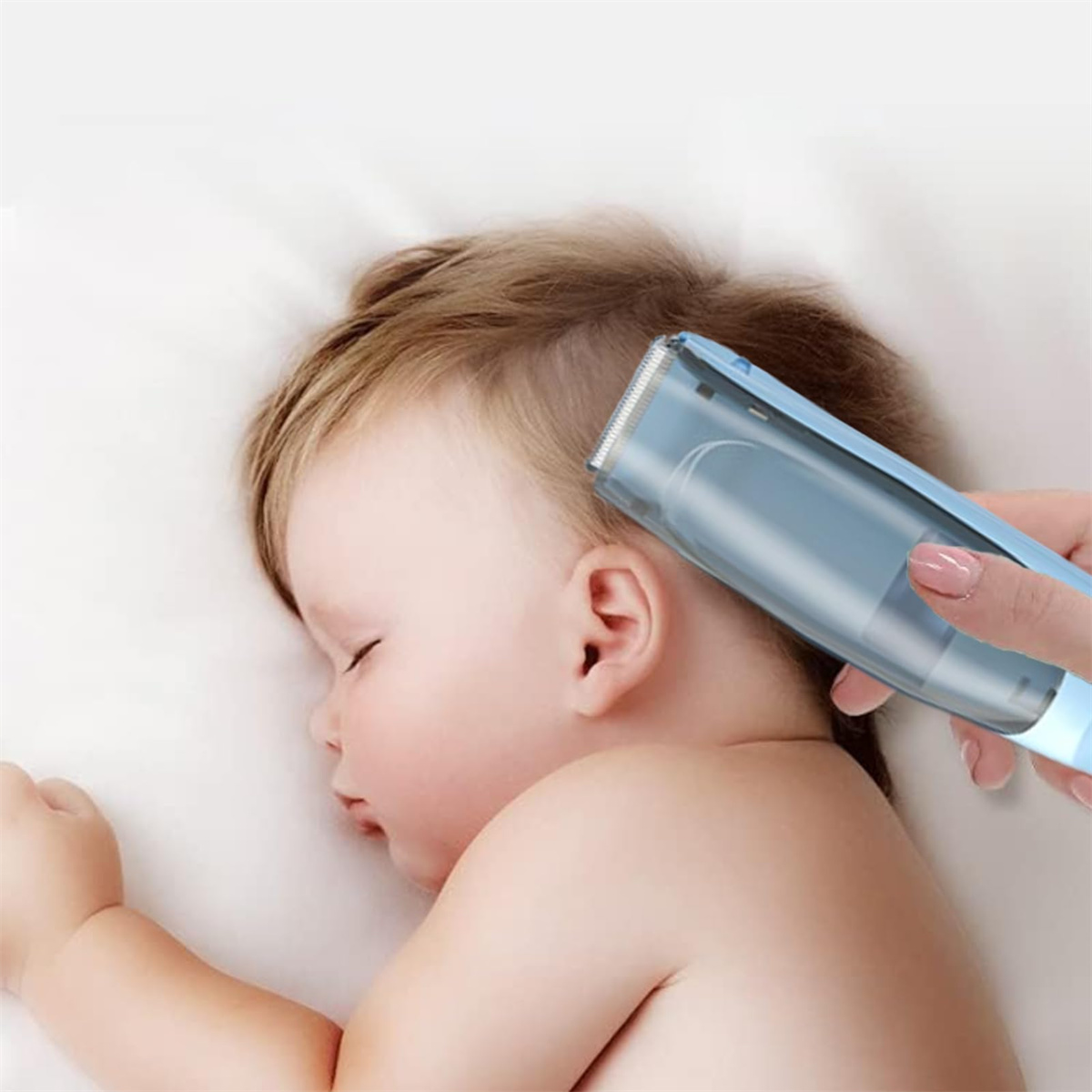 Ein Baby wird mit einem blauen Haarschneider rasiert. Das Baby liegt.