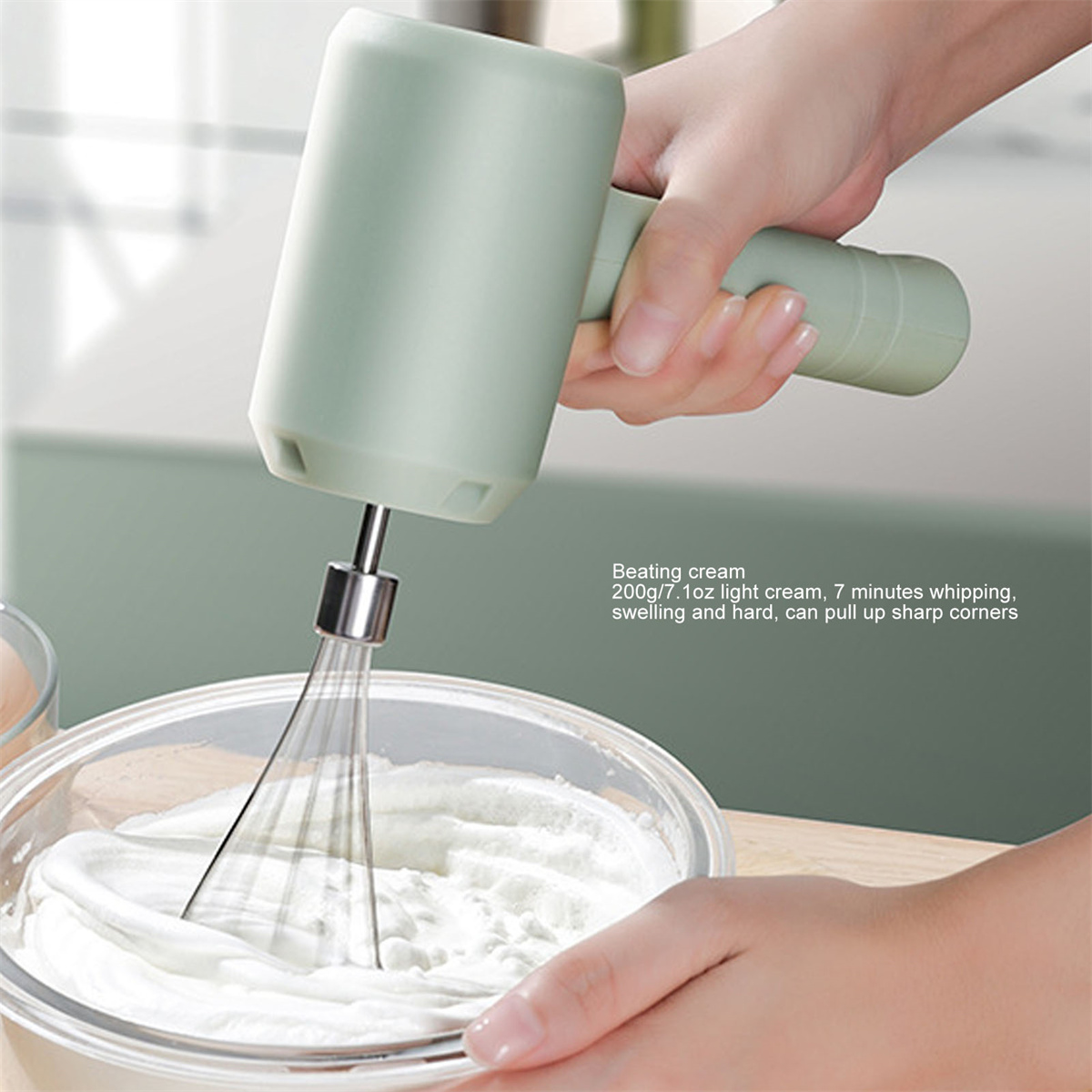 Eine Hand hält einen grünen elektrischen Mixer über einer Schüssel mit Sahne.