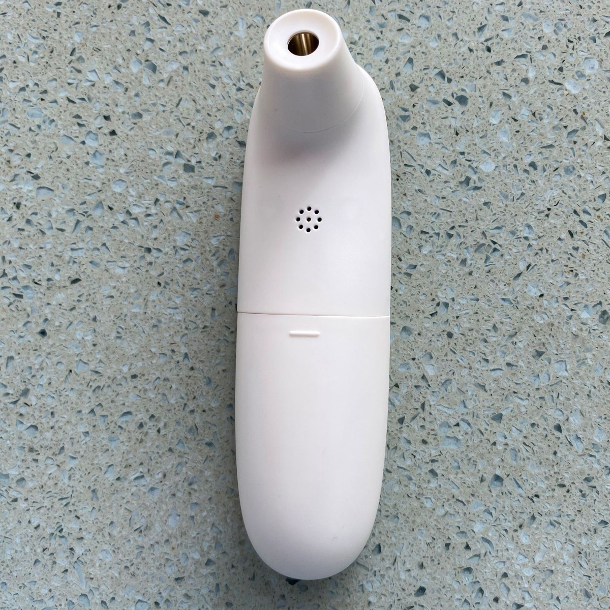 Ein weißes Ohrthermometer mit rundem Körper und kleiner Öffnung.