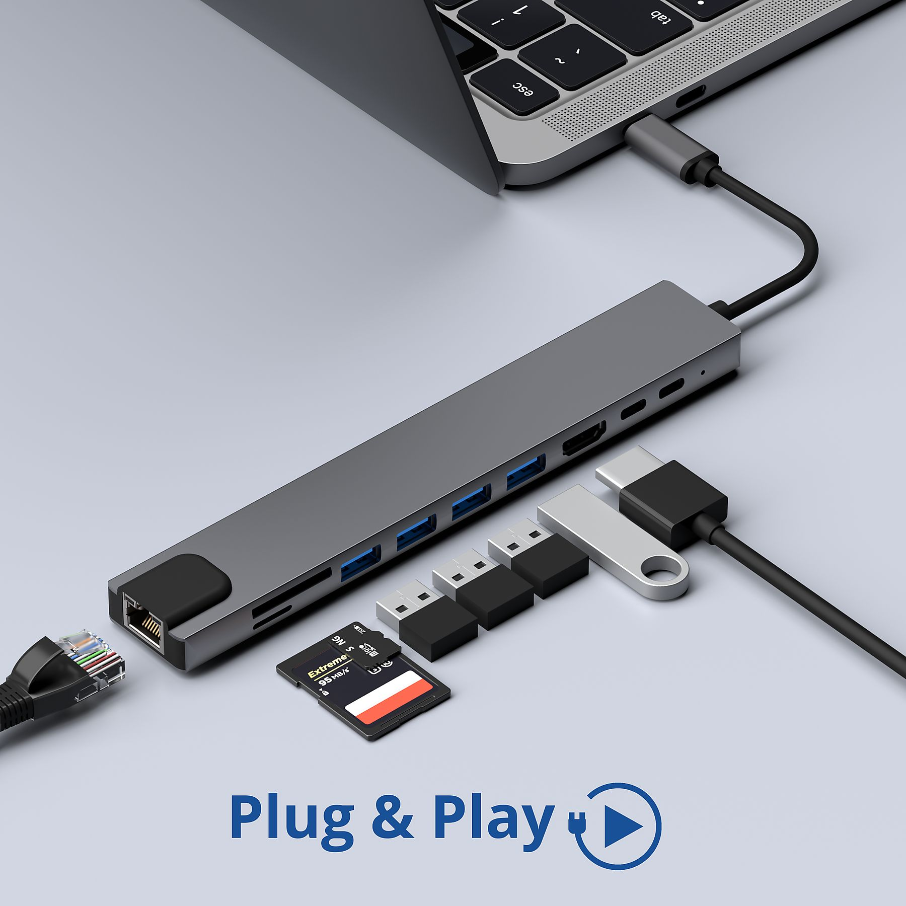 Laptop-Hub. Ein grauer Hub mit verschiedenen Anschlüssen, angeschlossen an einen Laptop und USB-Geräte.