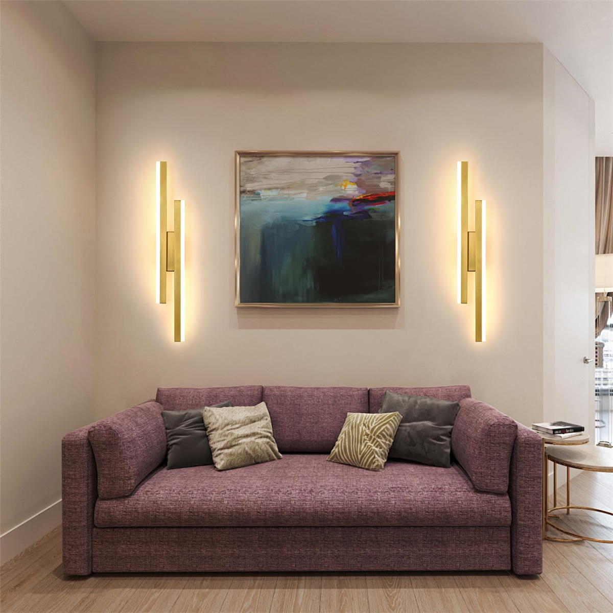 Innenaufnahme eines Wohnzimmers mit lila Sofa, Gemälde und wandmontierten goldenen Lichtern.