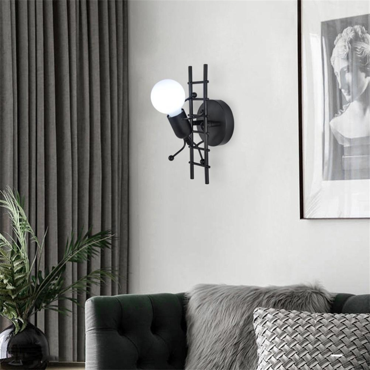 Schwarze Wandlampe in Form einer Leiter kletternden Person, mit einer leuchtenden Glühbirne.