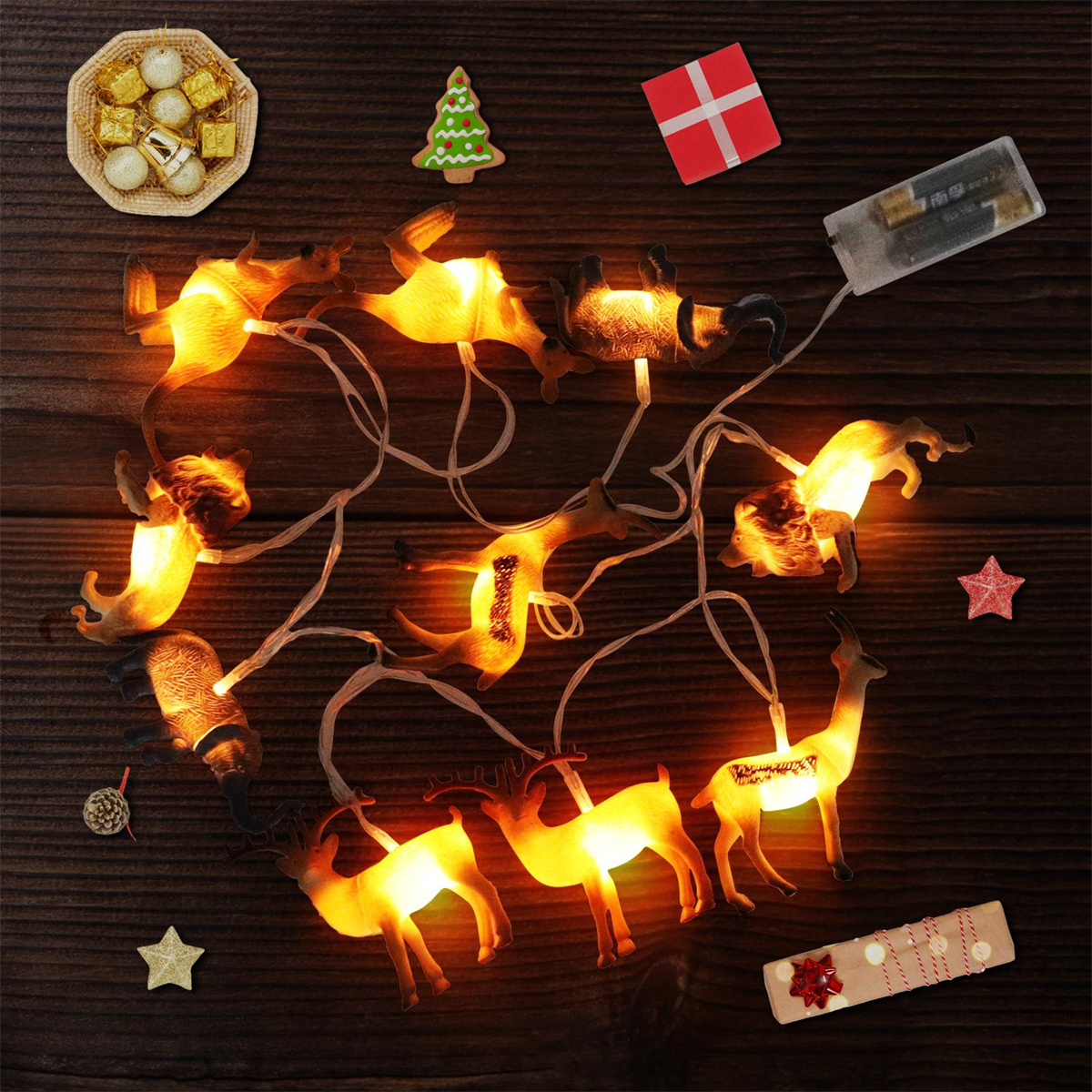 Weihnachtsbeleuchtung in Rentierform und festliche Dekorationen auf Holzgrund.