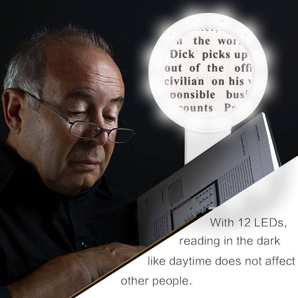 Mann liest mit Leselicht in einem Buch. Licht hat Text: "Dick picks up..."