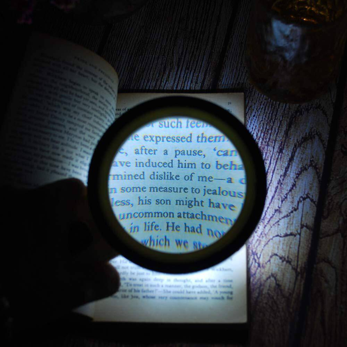 Lupe über einem Buch, mit beleuchtetem Text.