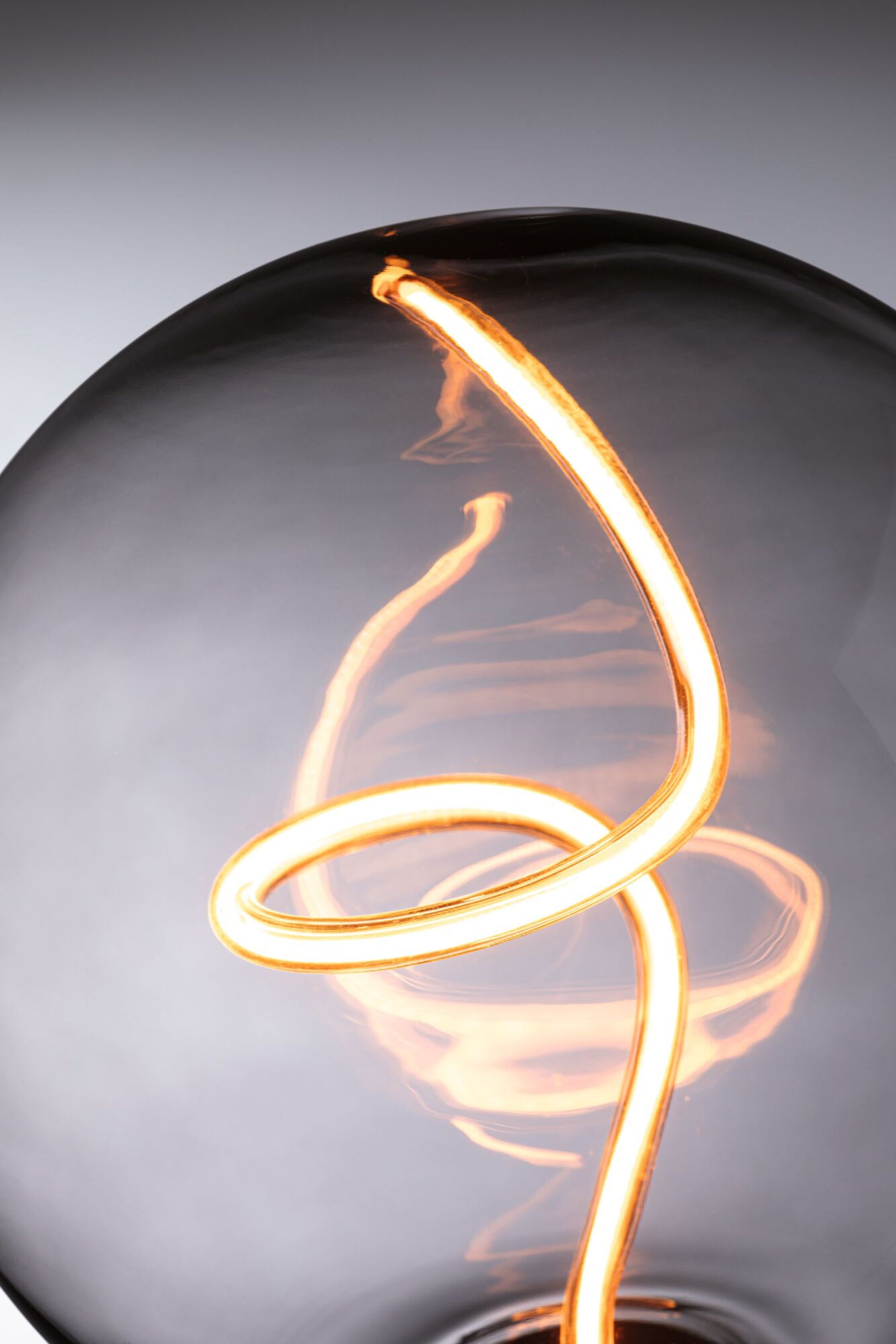 Zbliżenie świecącego żarnika żarówki.