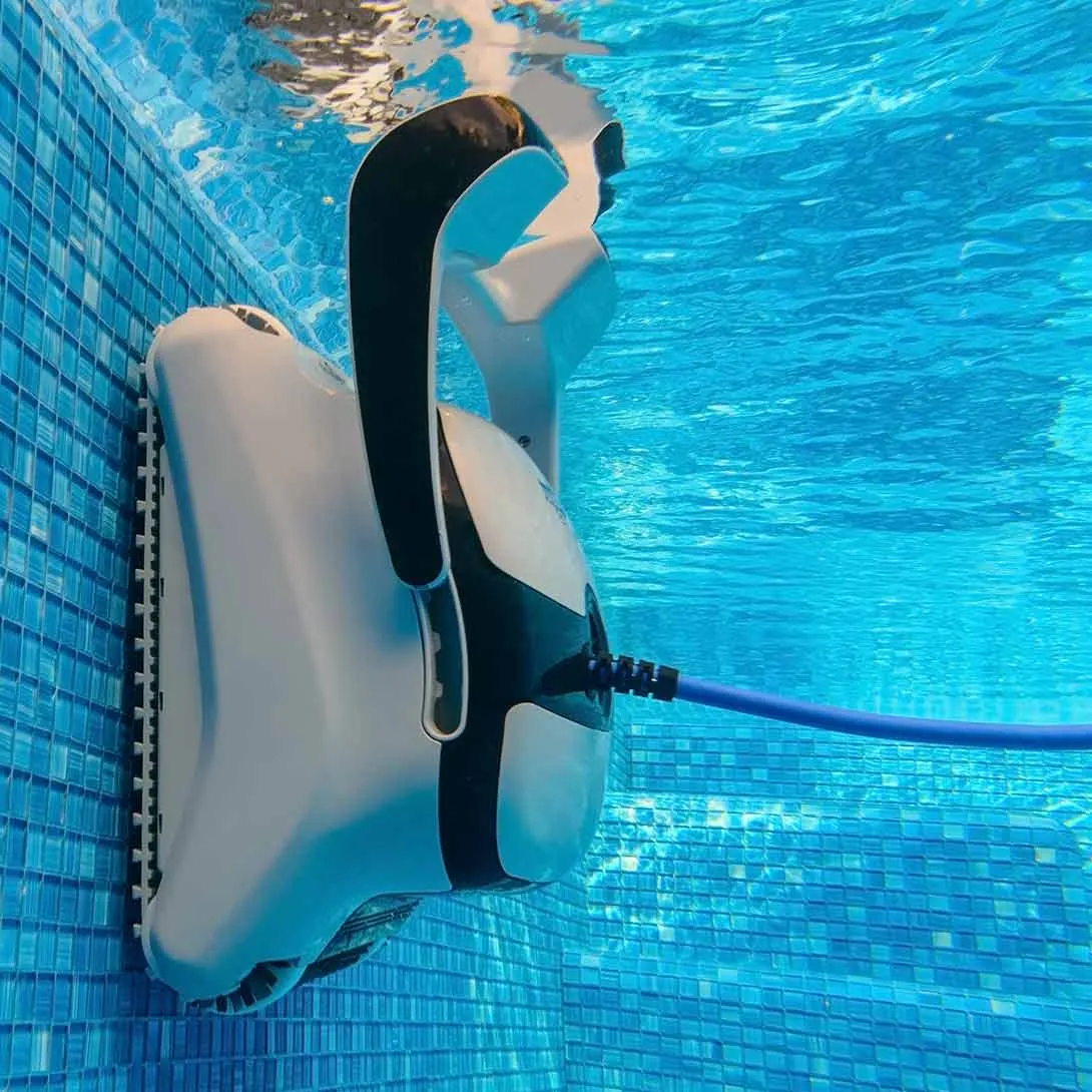 Ein Poolreinigungsroboter ist an der Poolwand befestigt, das Wasser ist blau und die Fliesen sind blau.