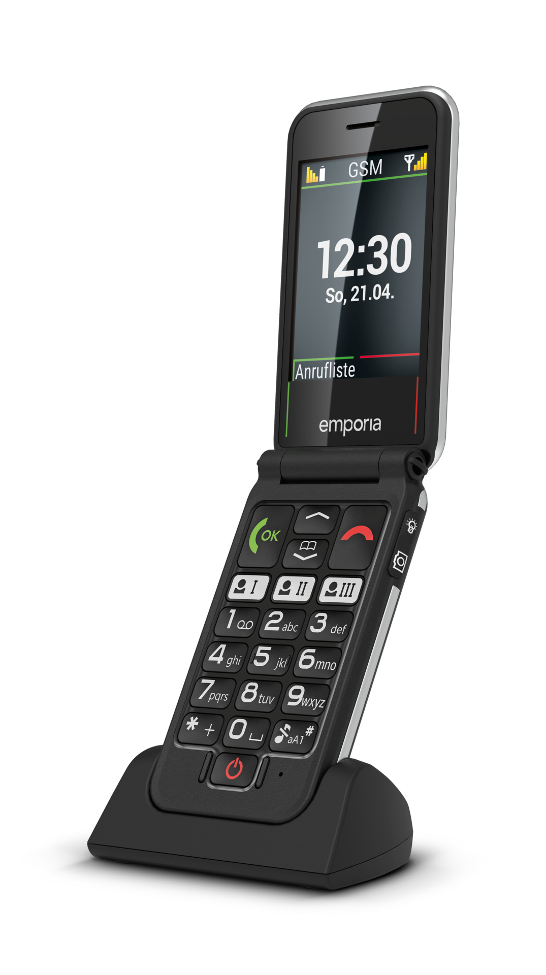 Un teléfono plegable negro en una base de carga, con hora y fecha.
