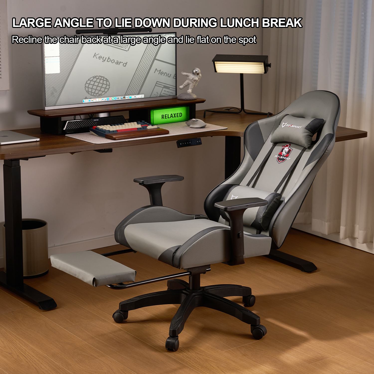 Una configuración de silla y escritorio para juegos, con monitor, teclado y reposapiés, en un entorno de habitación.