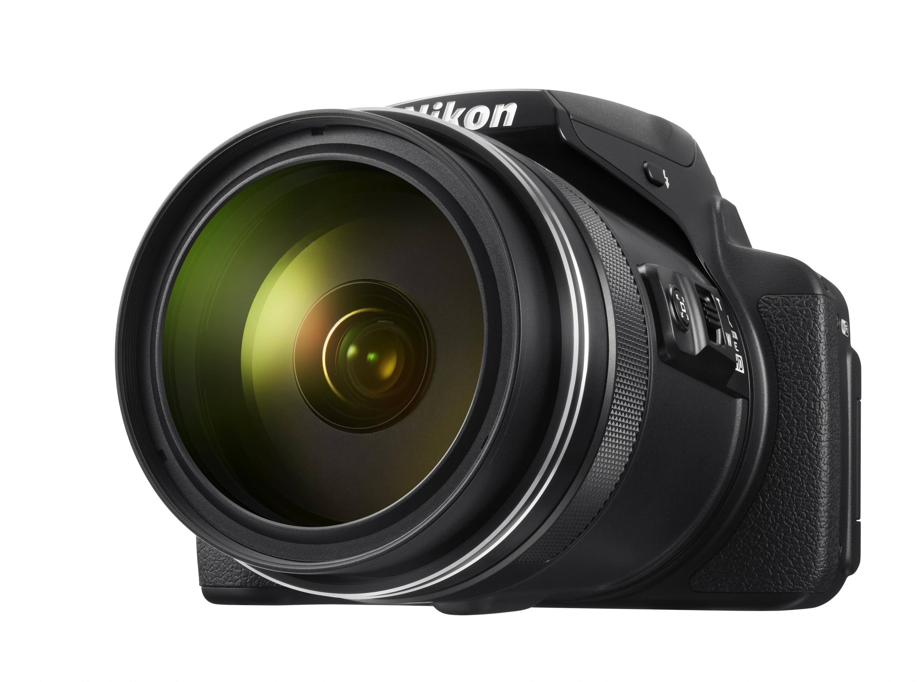 Eine schwarze Nikon-Kamera mit einem großen Objektiv. Das Objektiv hat einen grünen Farbton. Die Kamera steht auf weißem Hintergrund.