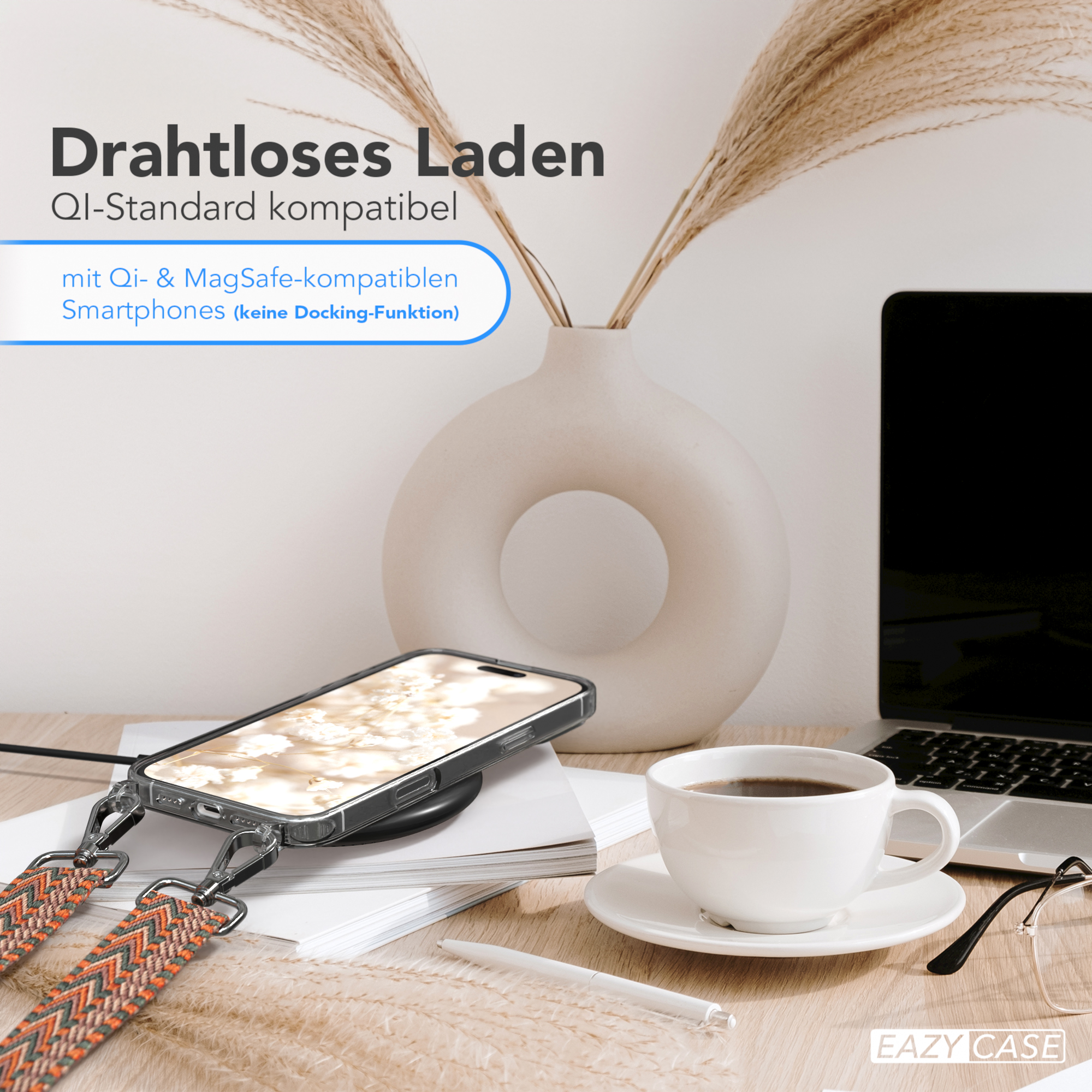 Telefon auf kabellosem Ladegerät mit Kaffeetasse und Vase. Im Hintergrund ein Laptop und eine Brille.