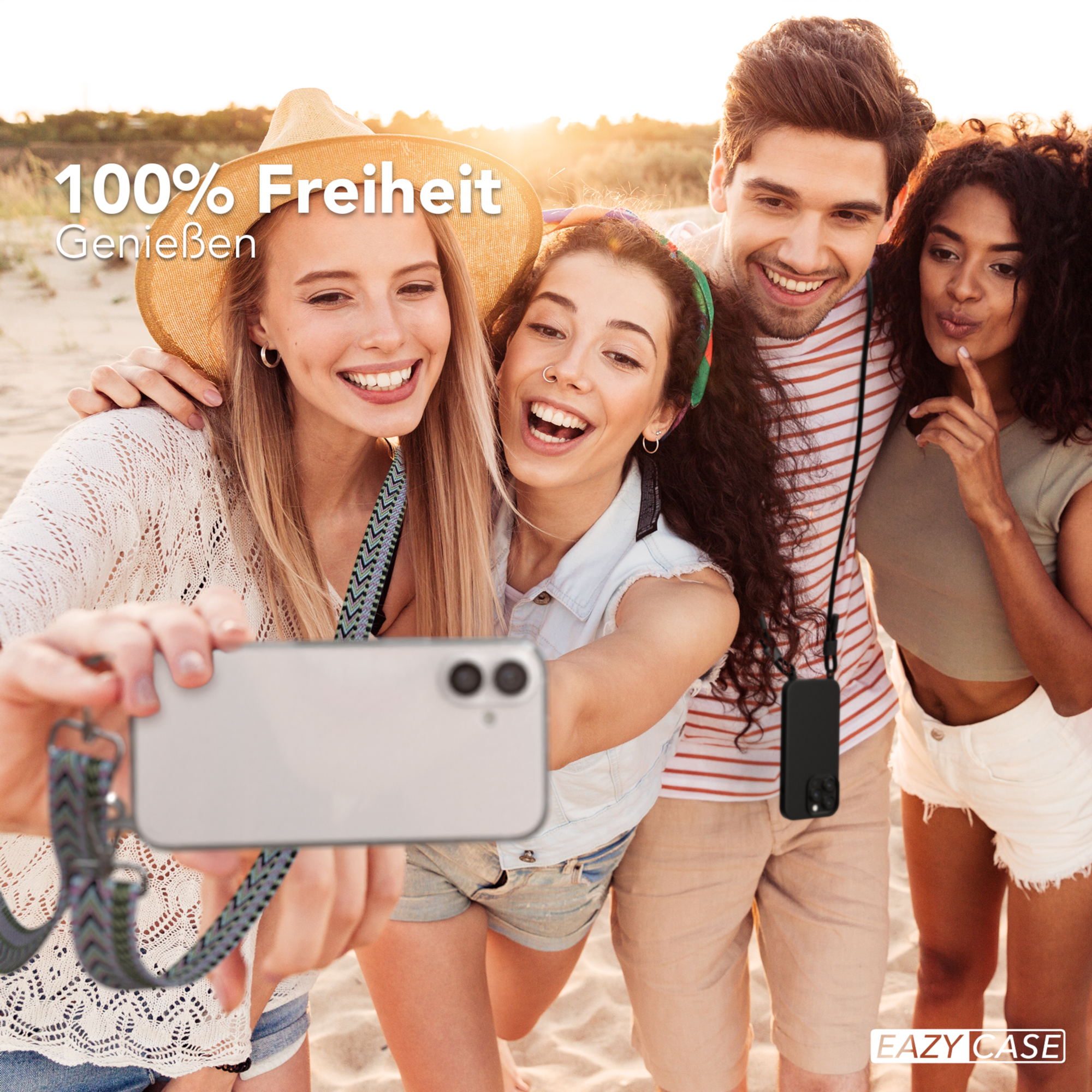 Vier Leute lächeln und machen ein Selfie am Strand. Sie halten ein Telefon mit gemustertem Gurt.