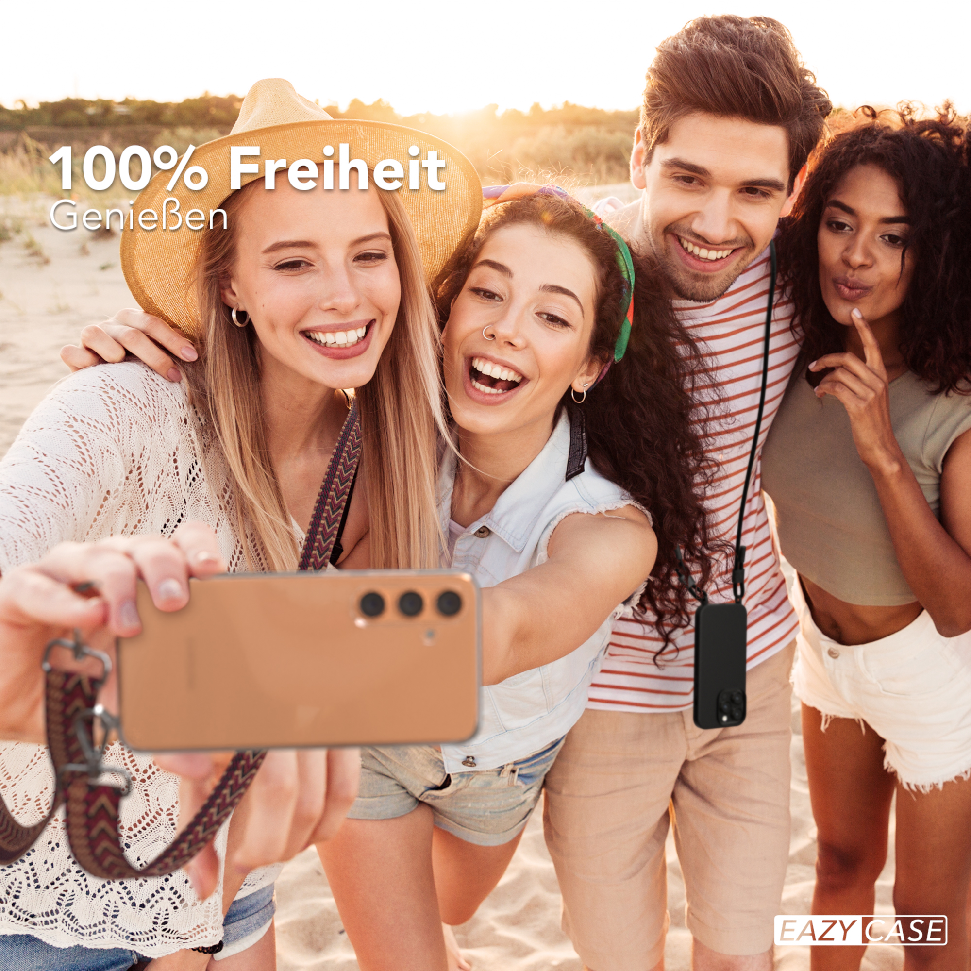 Vier Leute am Strand machen ein Selfie. Das Telefon hat ein Lanyard und einen Text mit '100% Freiheit'.