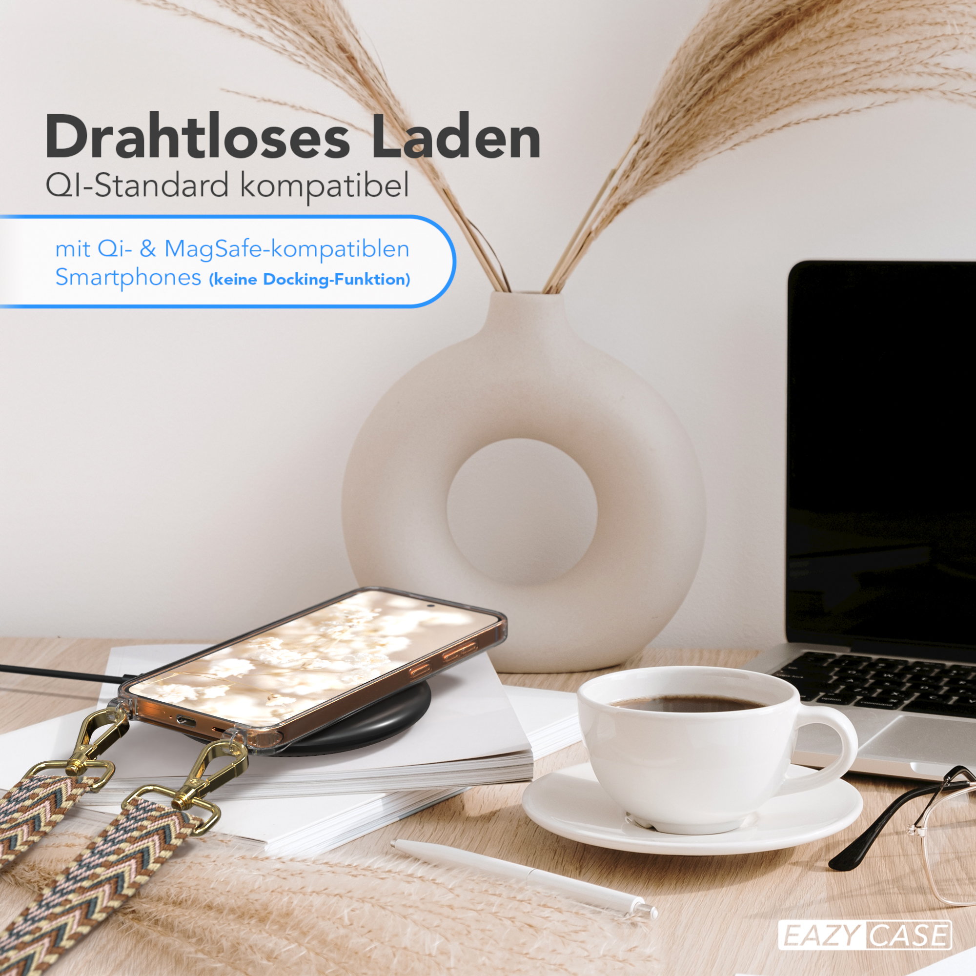 Ein Schreibtisch mit einem kabellos ladenden Telefon, einer Kaffeetasse, einer Vase mit Pflanzen und einem Laptop.