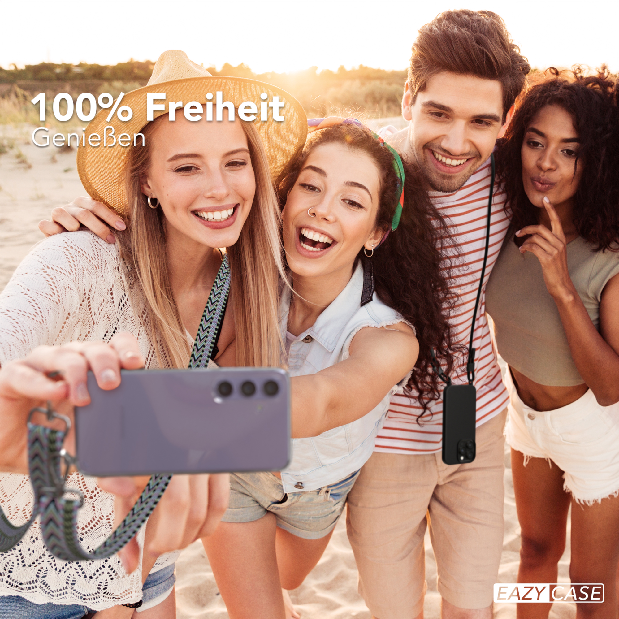 Gruppe von vier Personen, die ein Selfie am Strand machen. Zwei Mädchen halten das Telefon.
