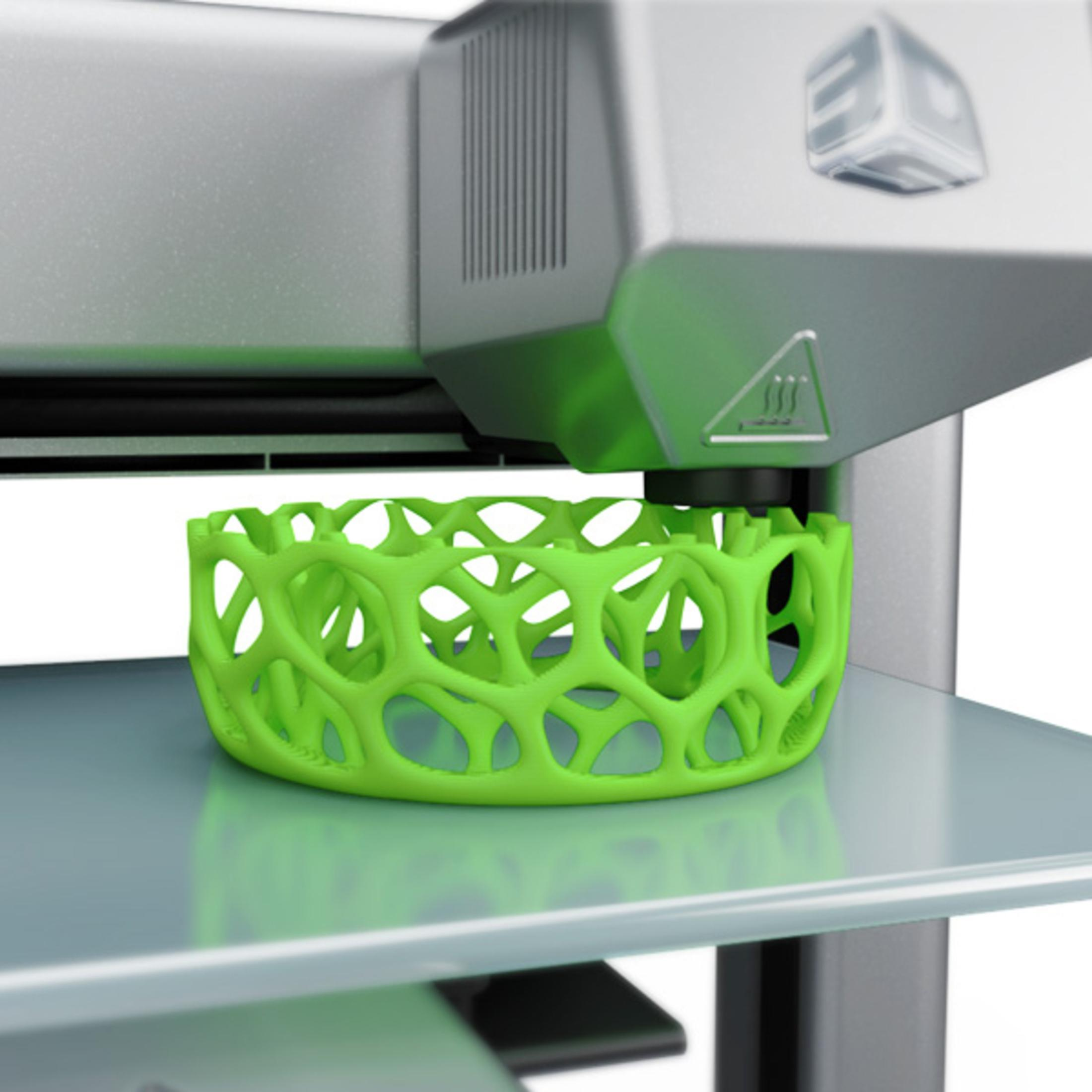 3D-Drucker, der eine grüne, offen strukturierte Schüssel auf einer silbernen Plattform erstellt.