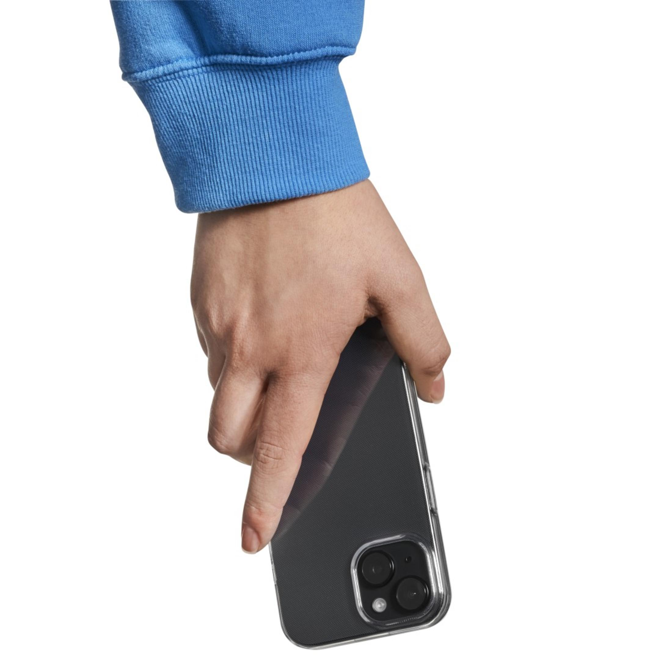 Osoba trzymająca smartfon z przezroczystym etui. Widoczny niebieski rękaw. Białe tło.