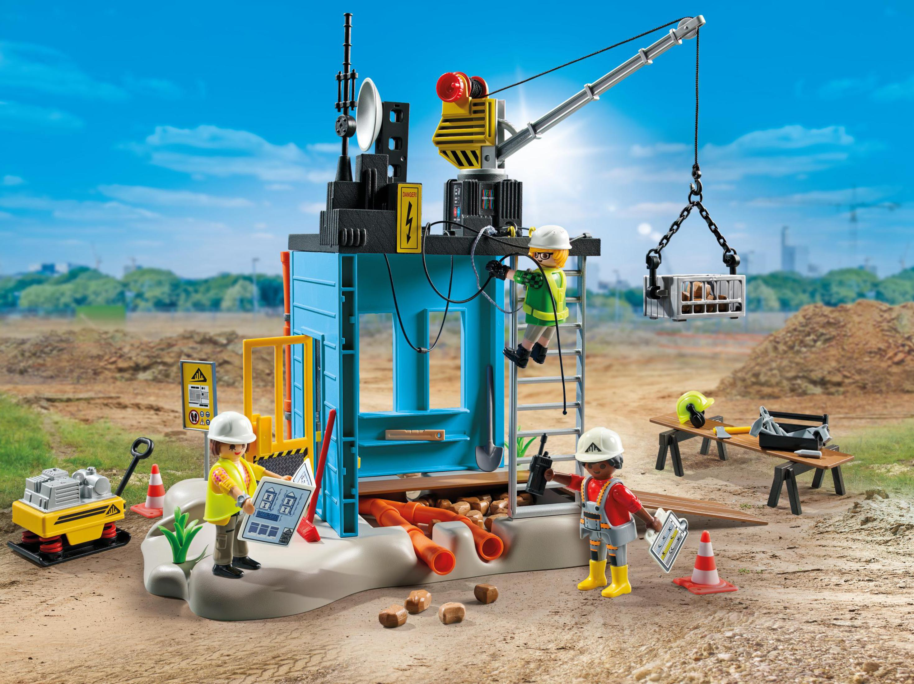 Cantiere con operai giocattolo, una gru e materiali edili.