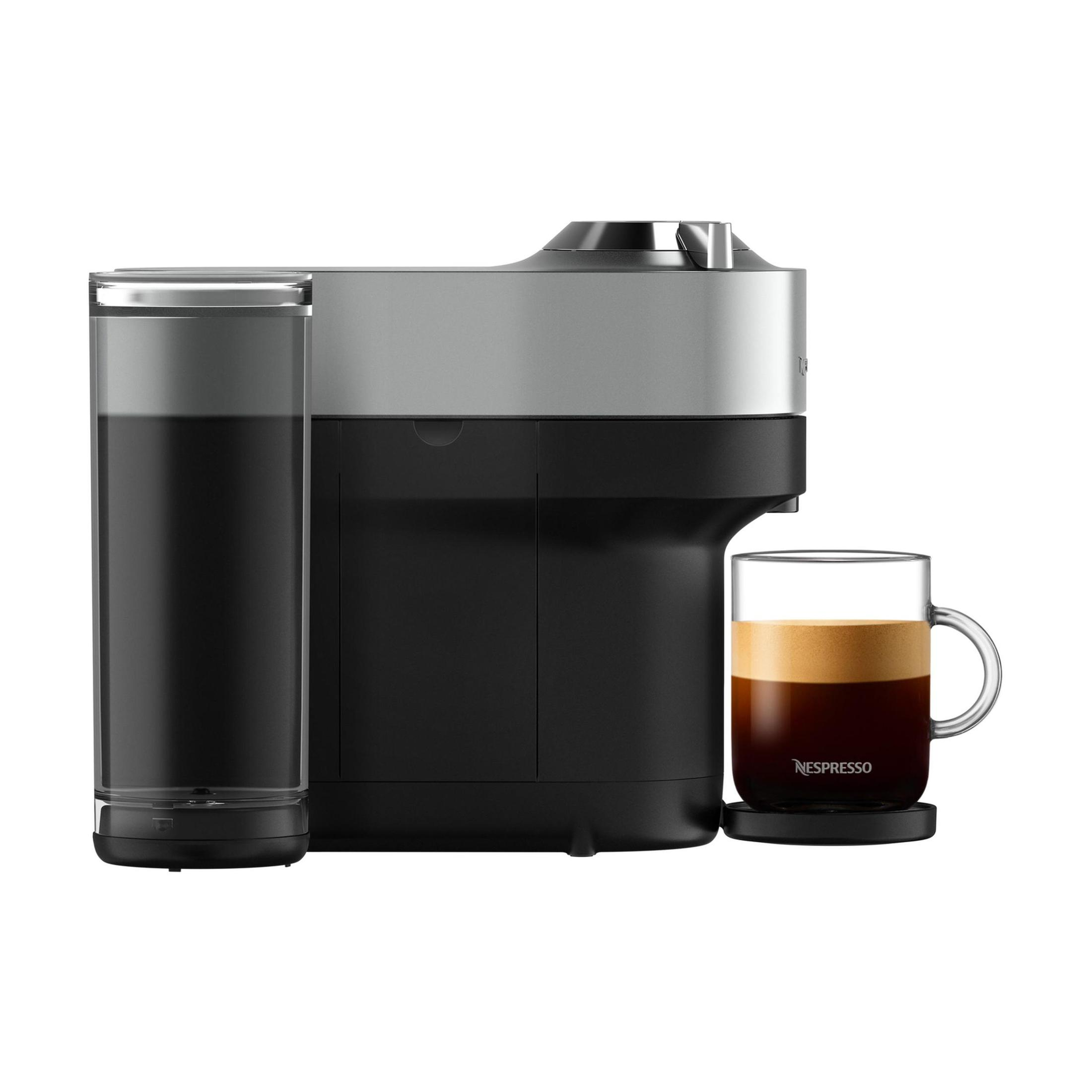 Una macchina da caffè Nespresso, con un serbatoio d'acqua e una tazza di caffè su un sottobicchiere.