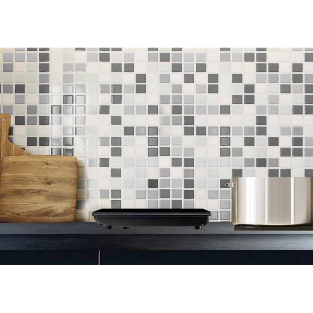 Schwarzes Gerät auf Arbeitsplatte mit Mosaikfliesen im Hintergrund.