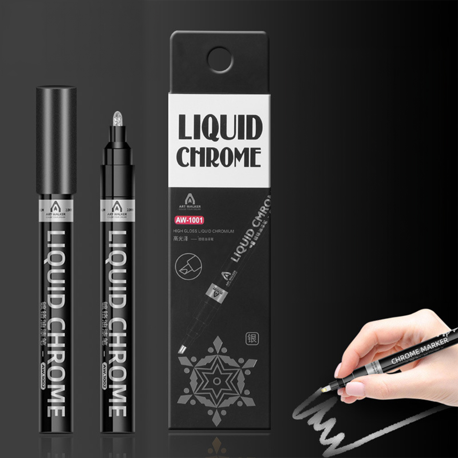 Dos rotuladores Liquid Chrome negros y una caja. Una mano dibuja con uno de los rotuladores.